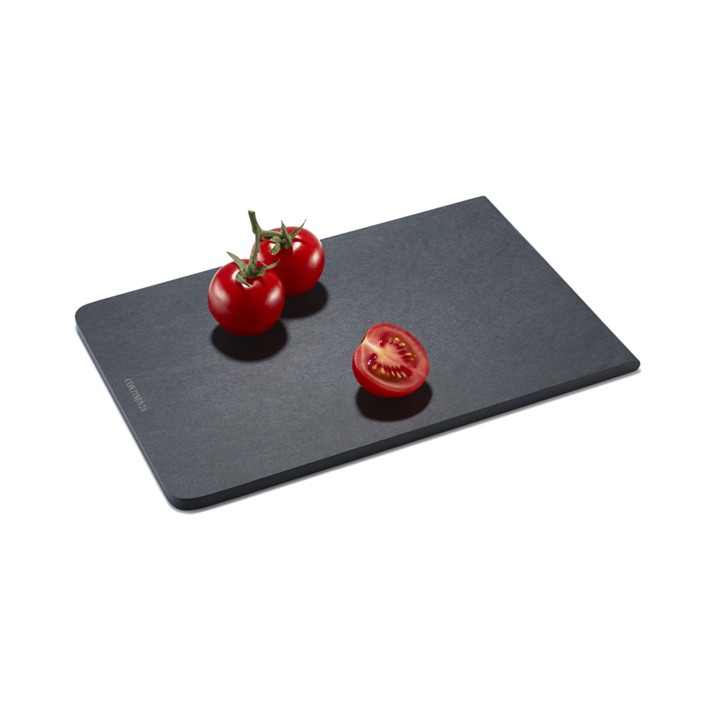 Ein schwarzes Schneidebrett mit zwei ganzen Tomaten und einer halbierten Tomate.