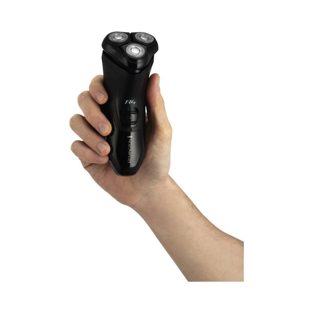 Eine Hand hält einen schwarzen Remington Rasierer mit drei rotierenden Köpfen.