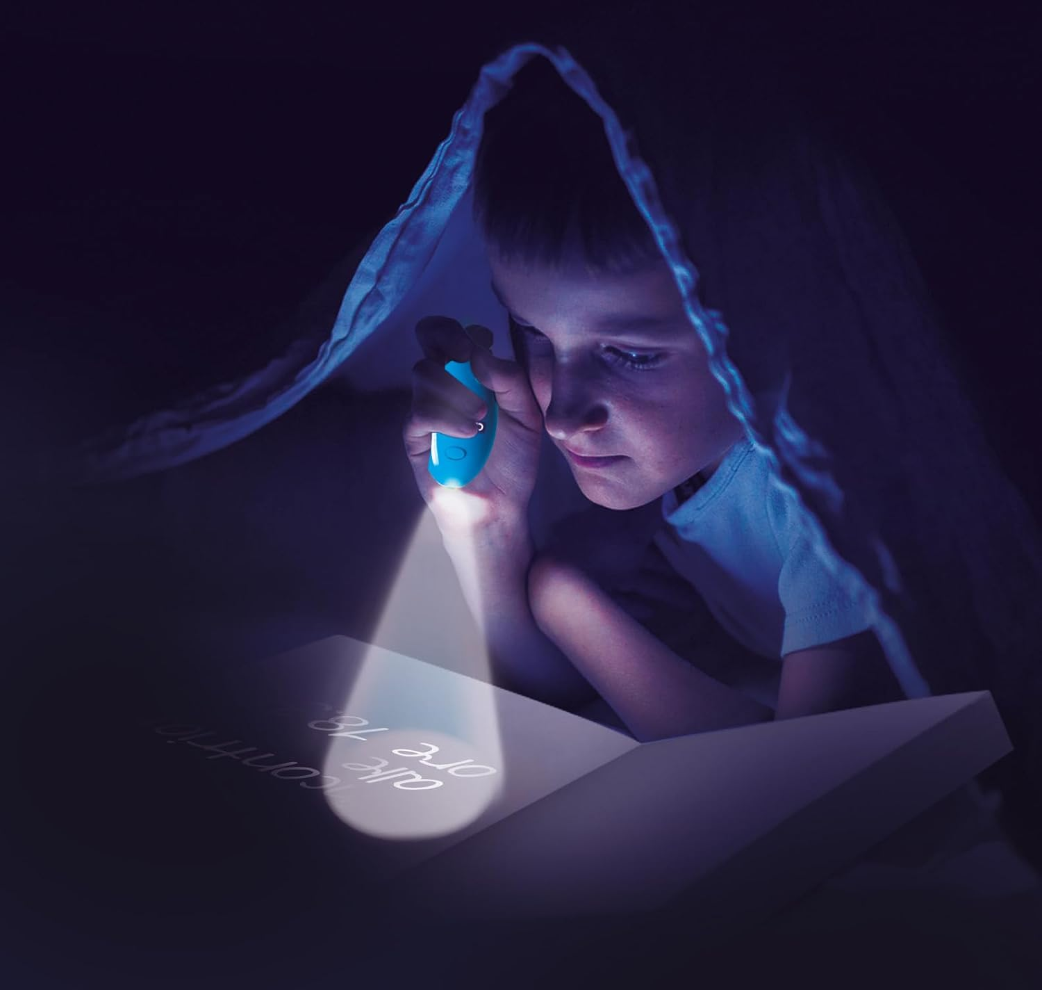 Ein Junge liest unter einer Decke mit einer blauen Taschenlampe ein Buch.