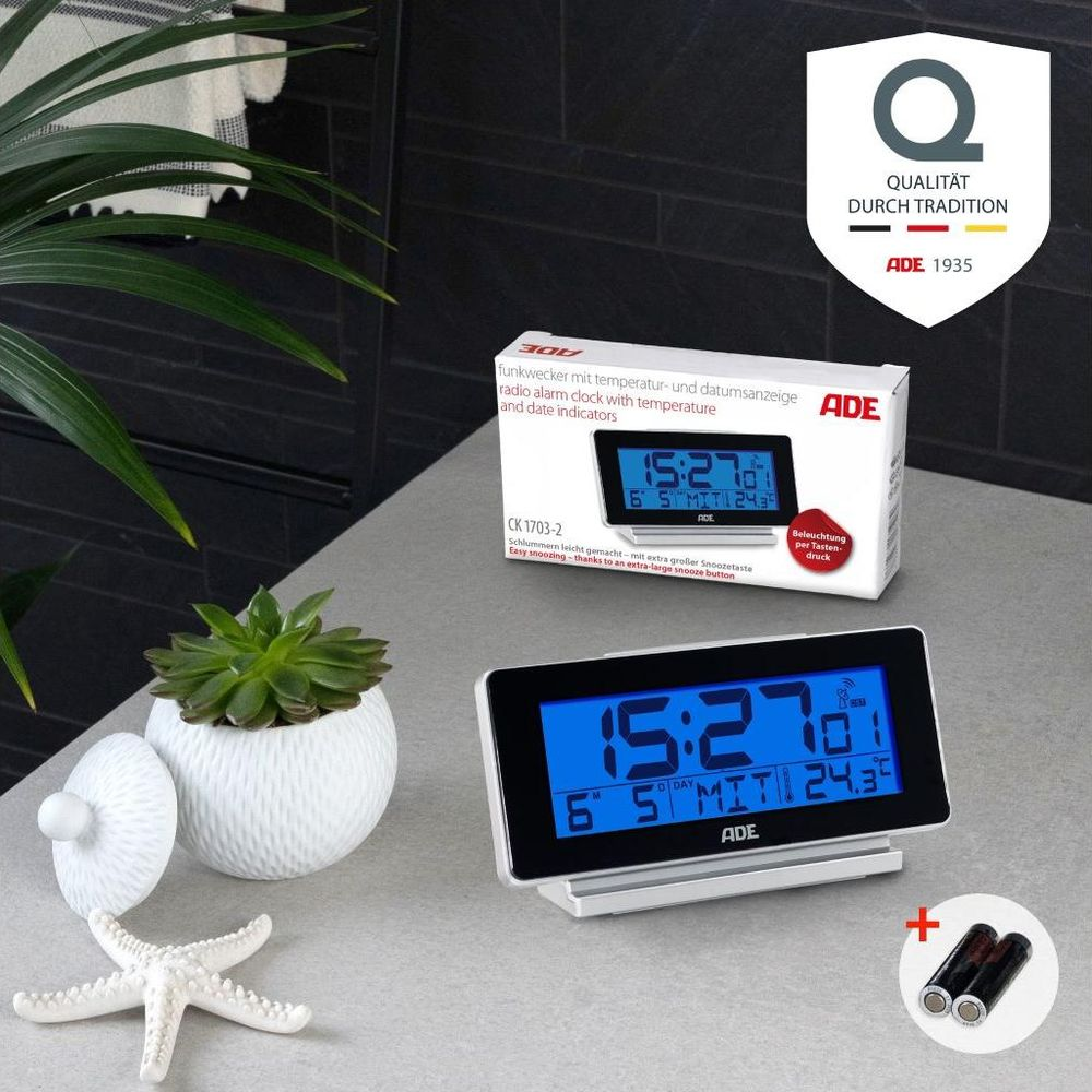 ADE Funkwecker mit Temperatur- und Datumsanzeige auf einem Tisch.