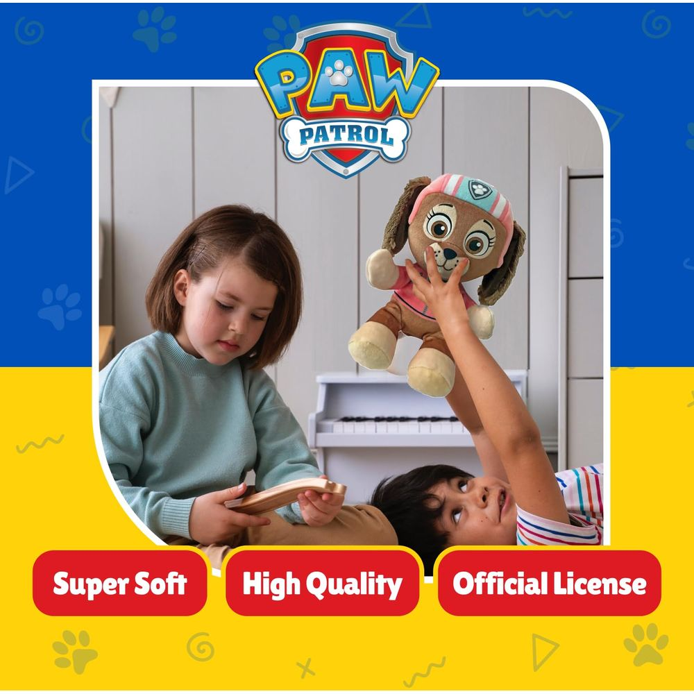 Zwei Kinder spielen mit einem Paw Patrol Plüschtier vor einem weißen Klavier.