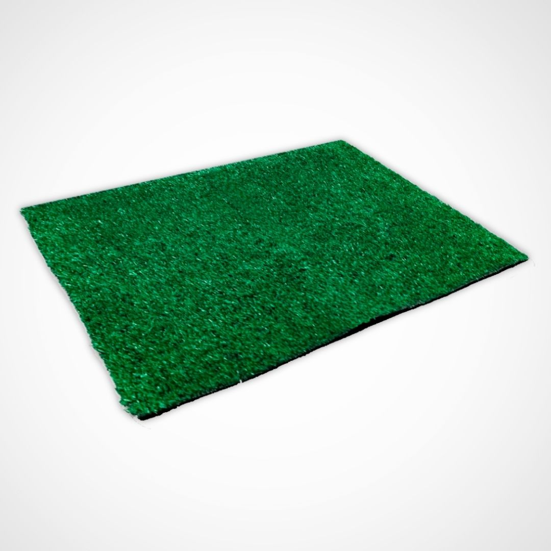 Una alfombra de césped artificial verde yace sobre un fondo blanco.