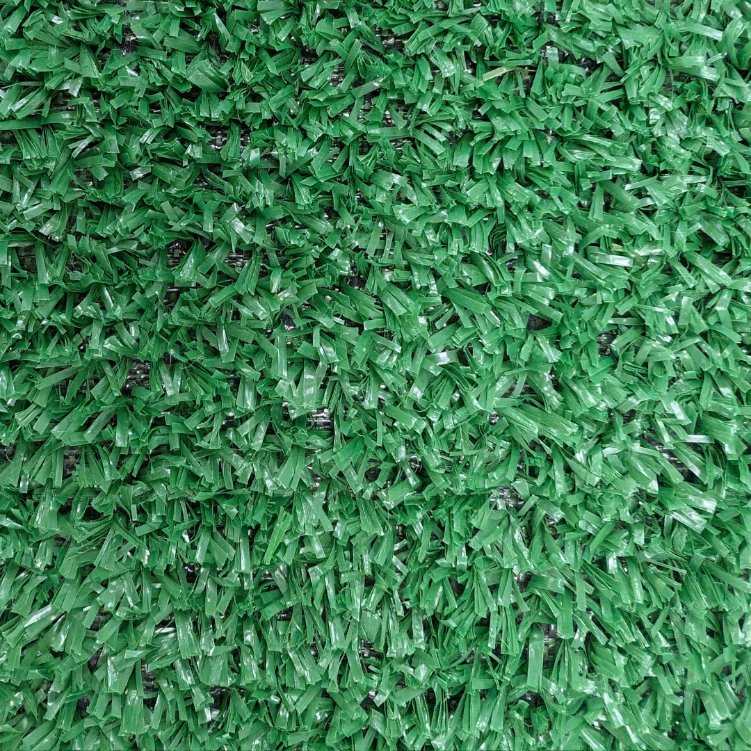 Vista de cerca de briznas de césped artificial verde, texturizadas y uniformes.