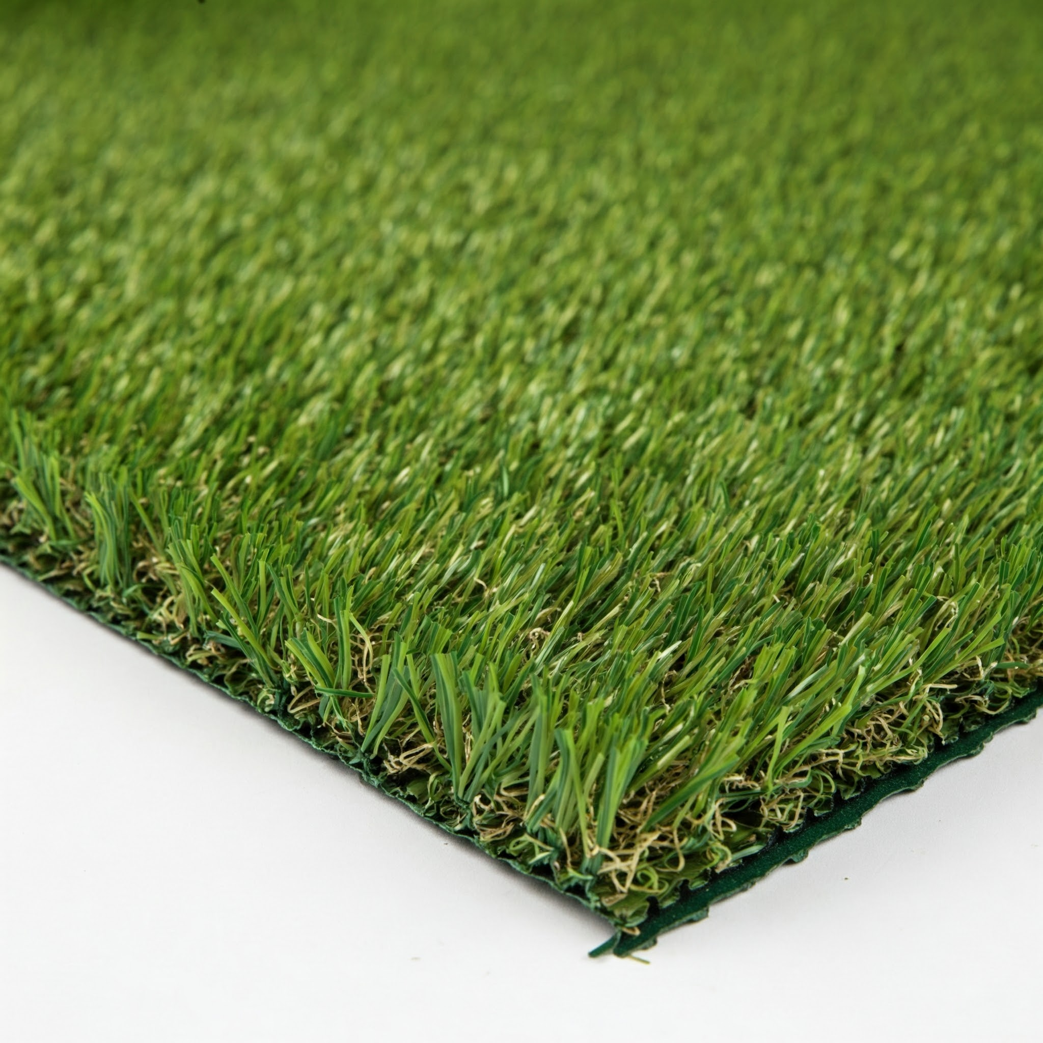 Primer plano de césped artificial con briznas verdes sobre fondo blanco.