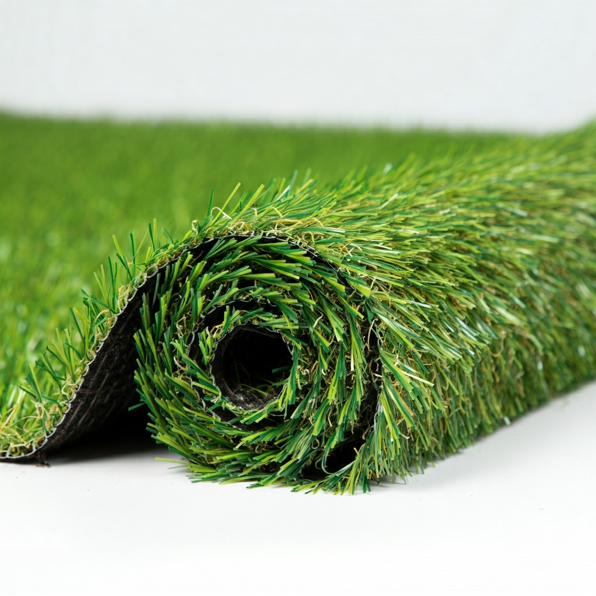 Un rollo de césped artificial con briznas verdes y base oscura.