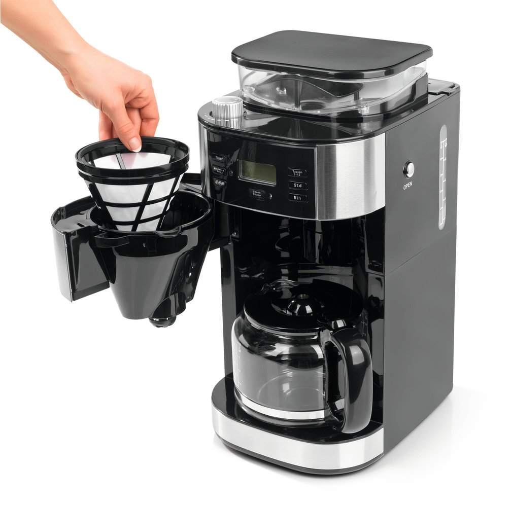 Una mano coloca un filtro de café en una cafetera negra con jarra de vidrio.
