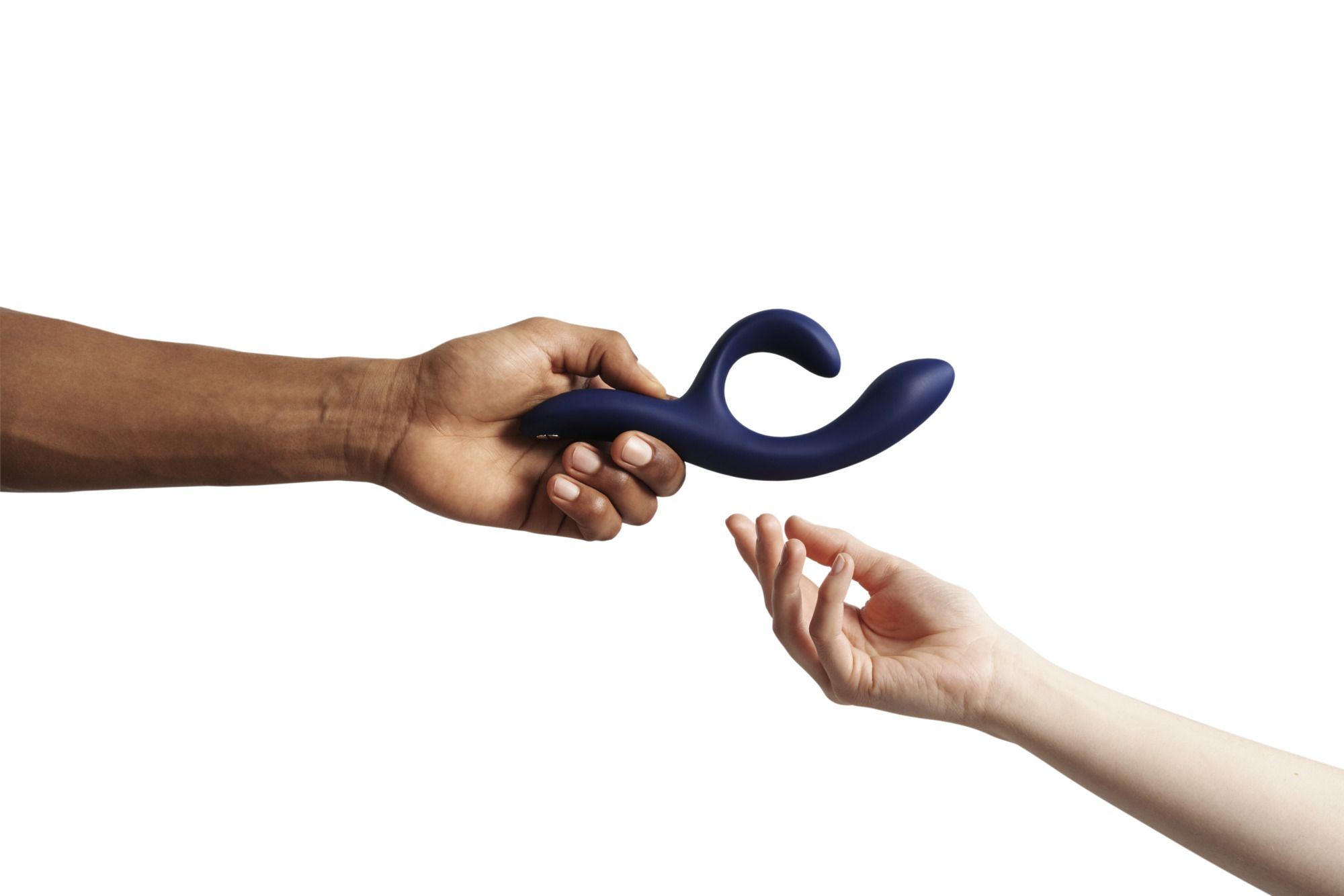 Eine dunkle Hand hält einen blauen Vibrator, während eine helle Hand ihn empfängt.