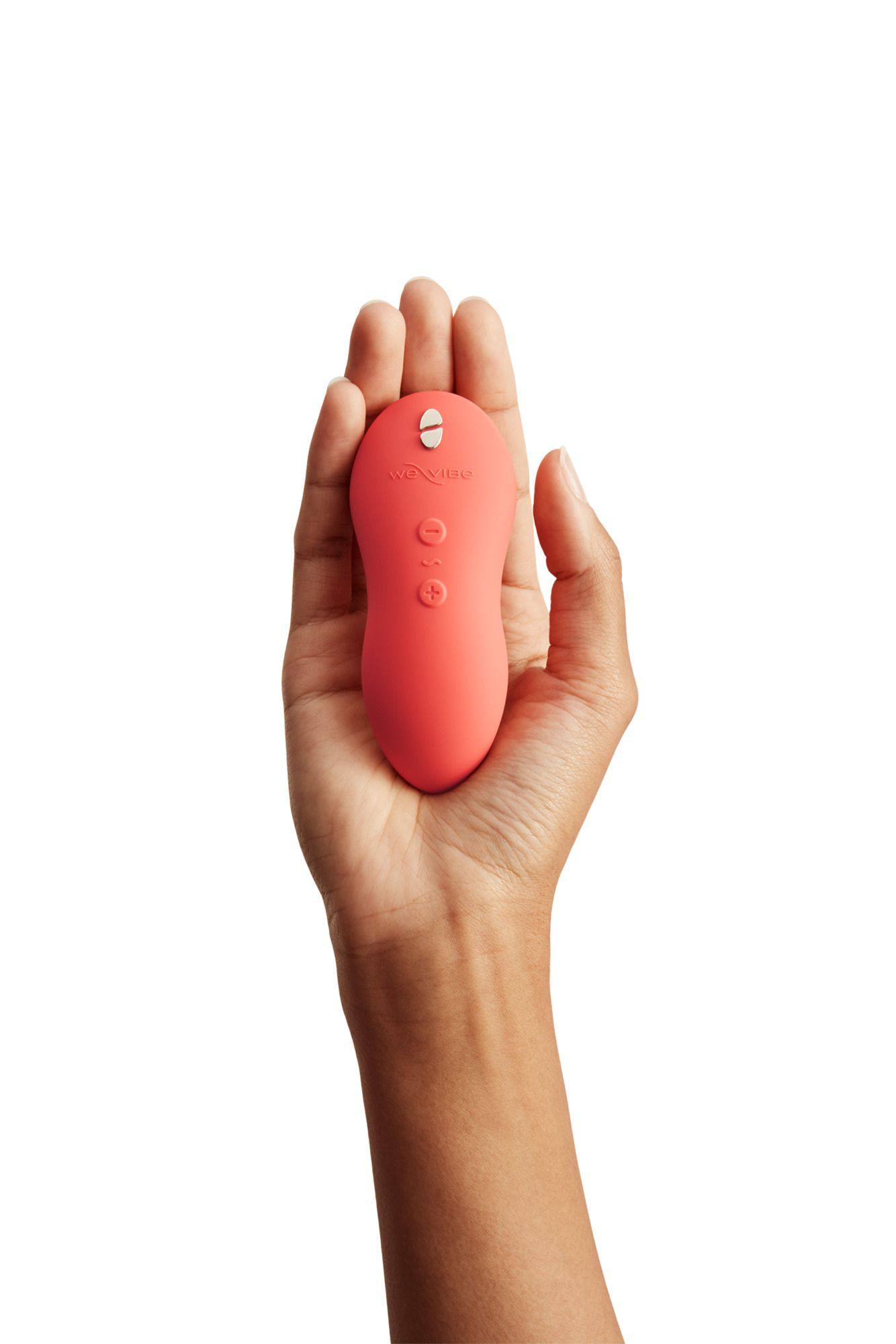Dłoń trzyma koralowy wibrator z przyciskami plus i minus.