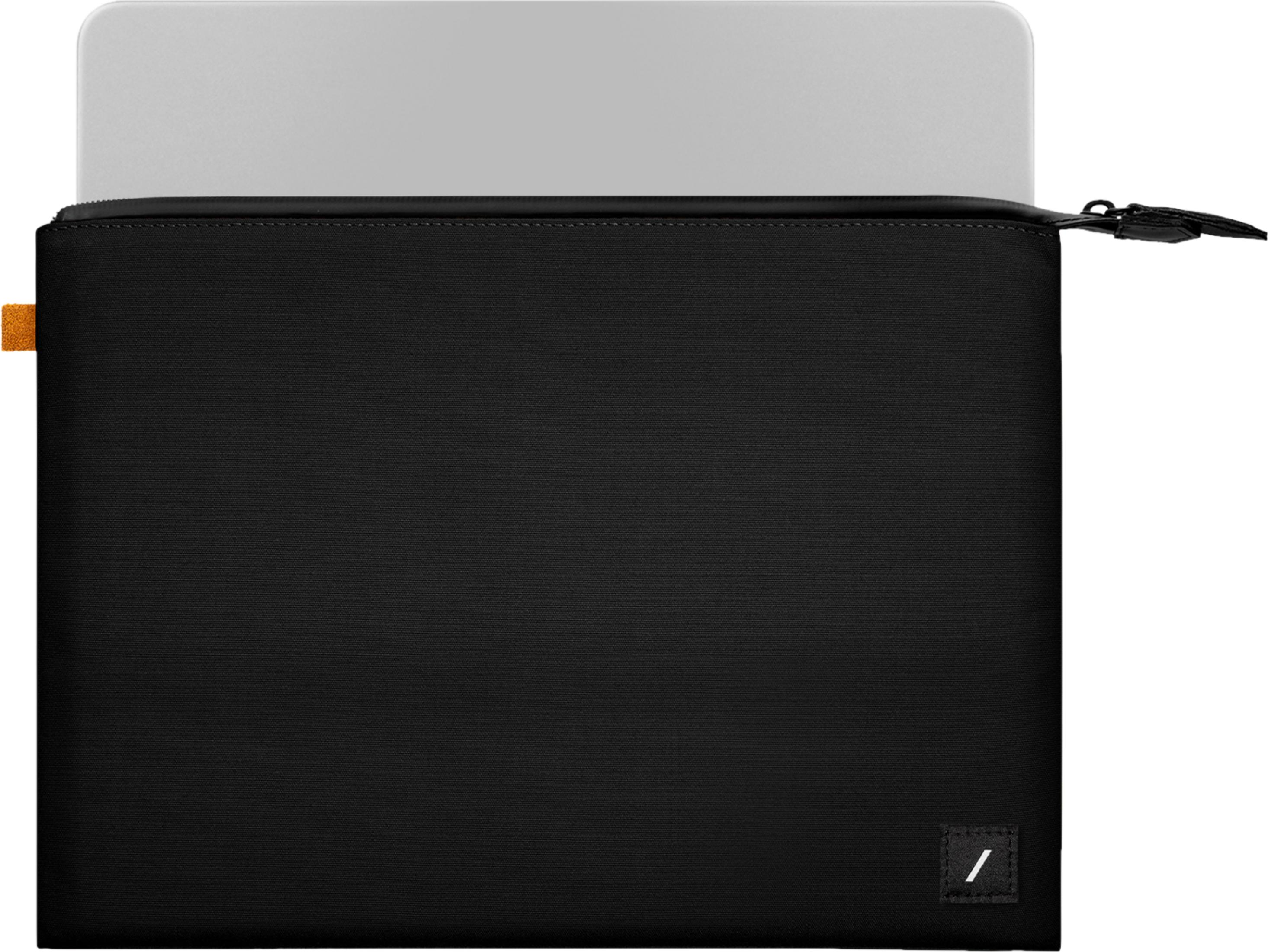 Un ordinateur portable argenté dépasse d'une pochette noire zippée. Design minimaliste.