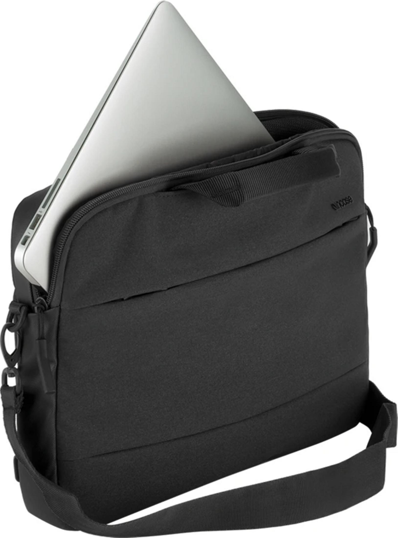 Un laptop argentato viene inserito in una borsa per laptop nera.