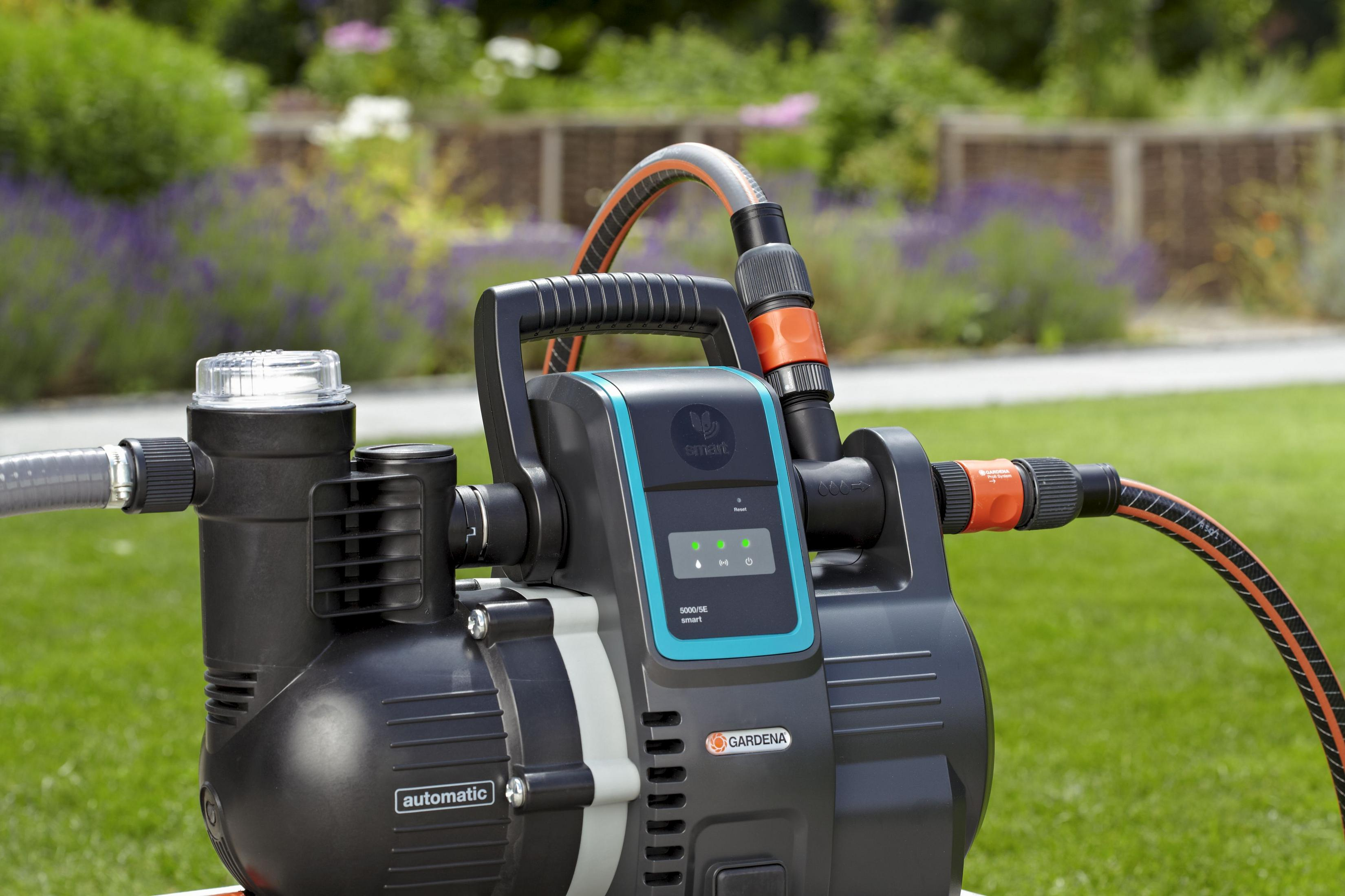 Un'unità automatica per l'approvvigionamento idrico Gardena nera con attacco per tubo su prato.