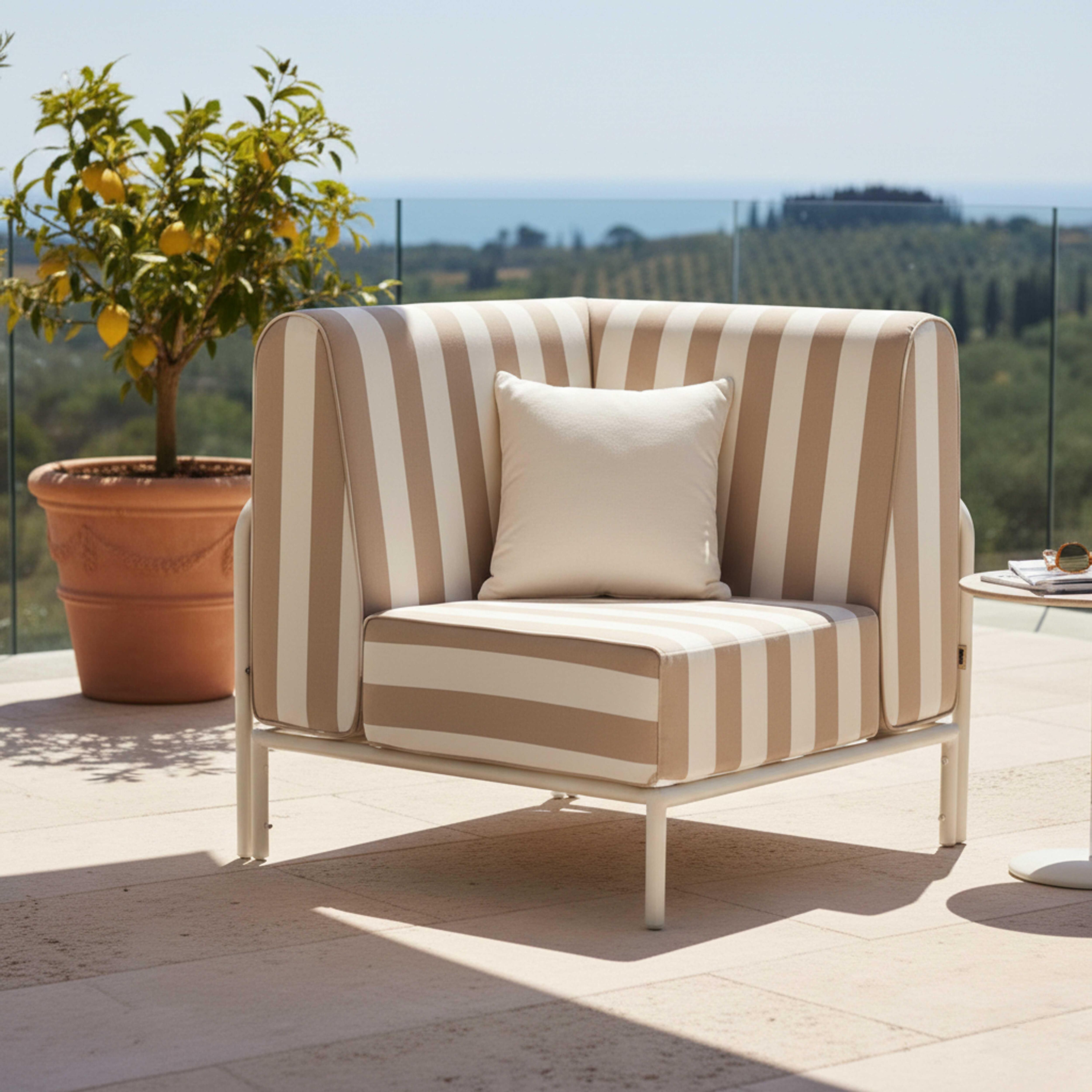 Gestreifter Sessel mit Kissen auf einer Terrasse mit Zitronenbaum und Meerblick.