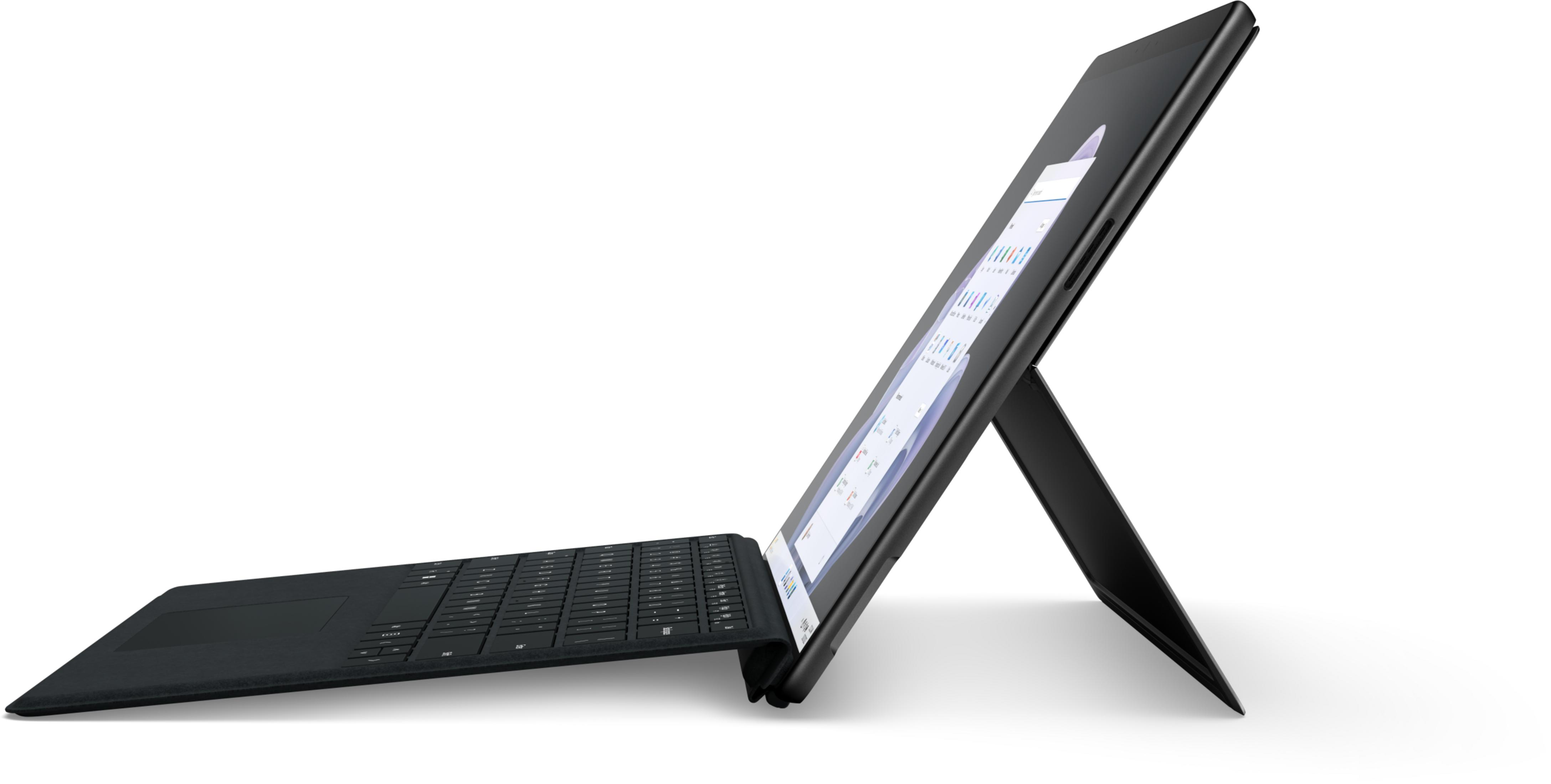 Czarny tablet z podłączoną klawiaturą, oparty na stojaku.