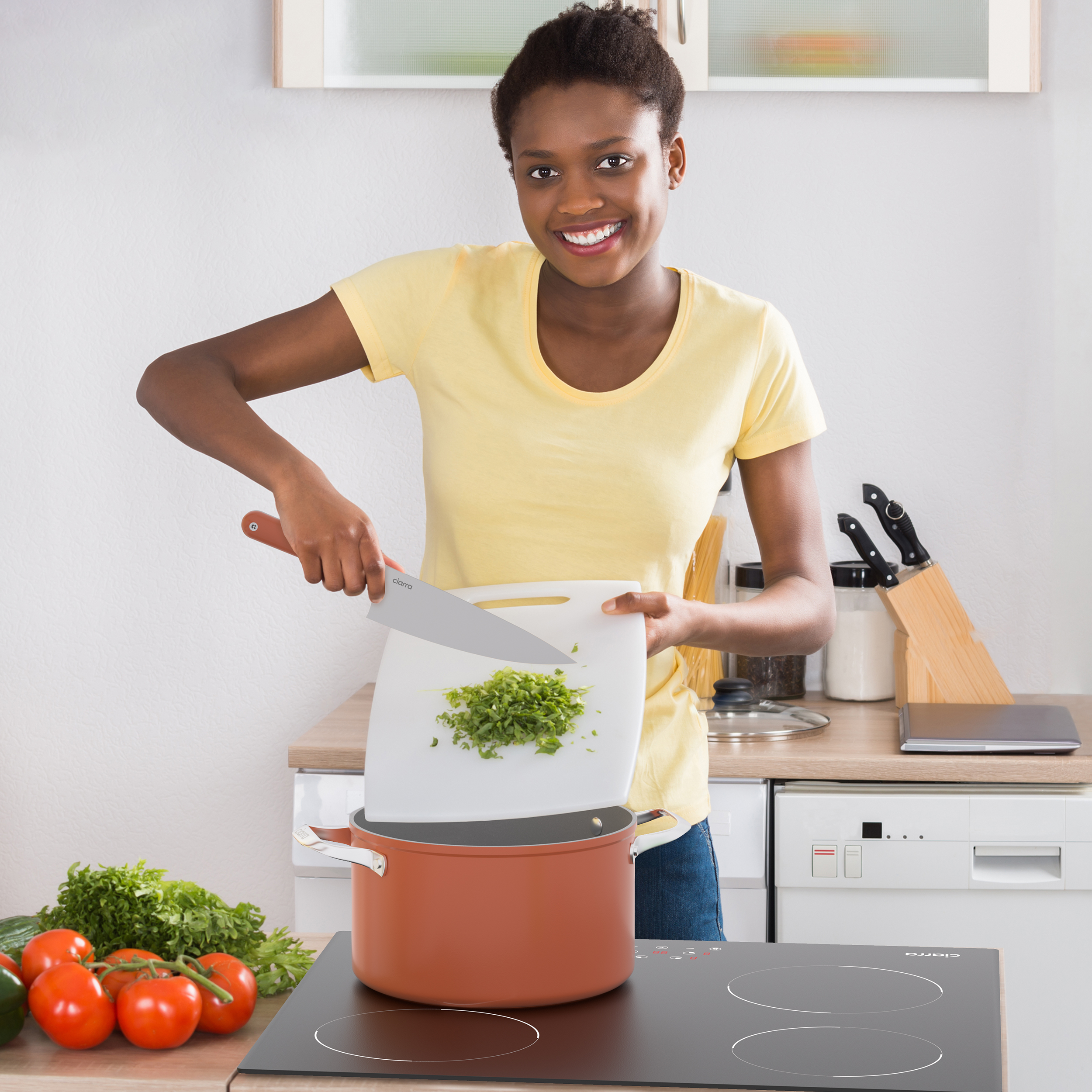 Une femme hache du persil dans une cuisine.