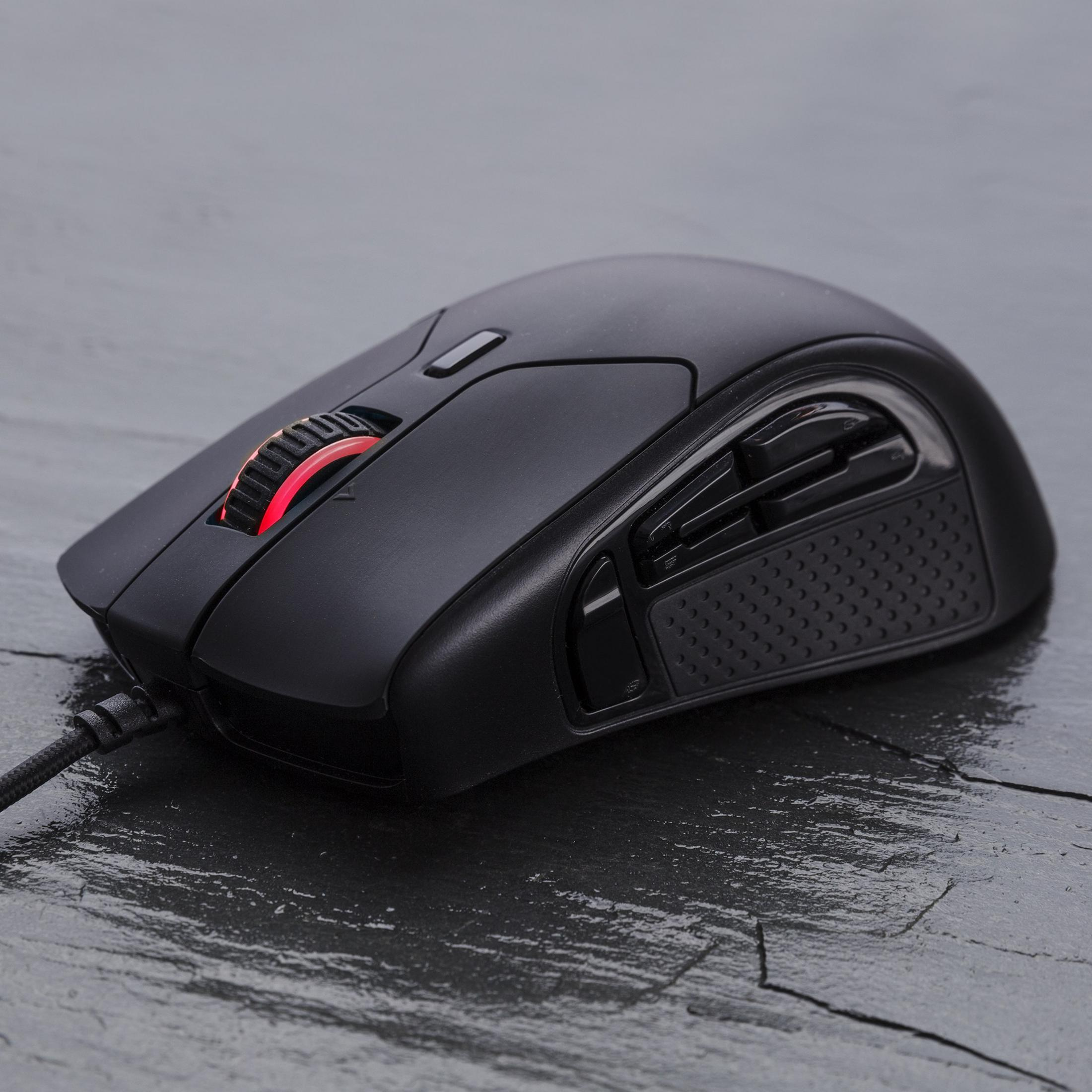 Mouse da gaming nero con rotella rossa su pietra scura.