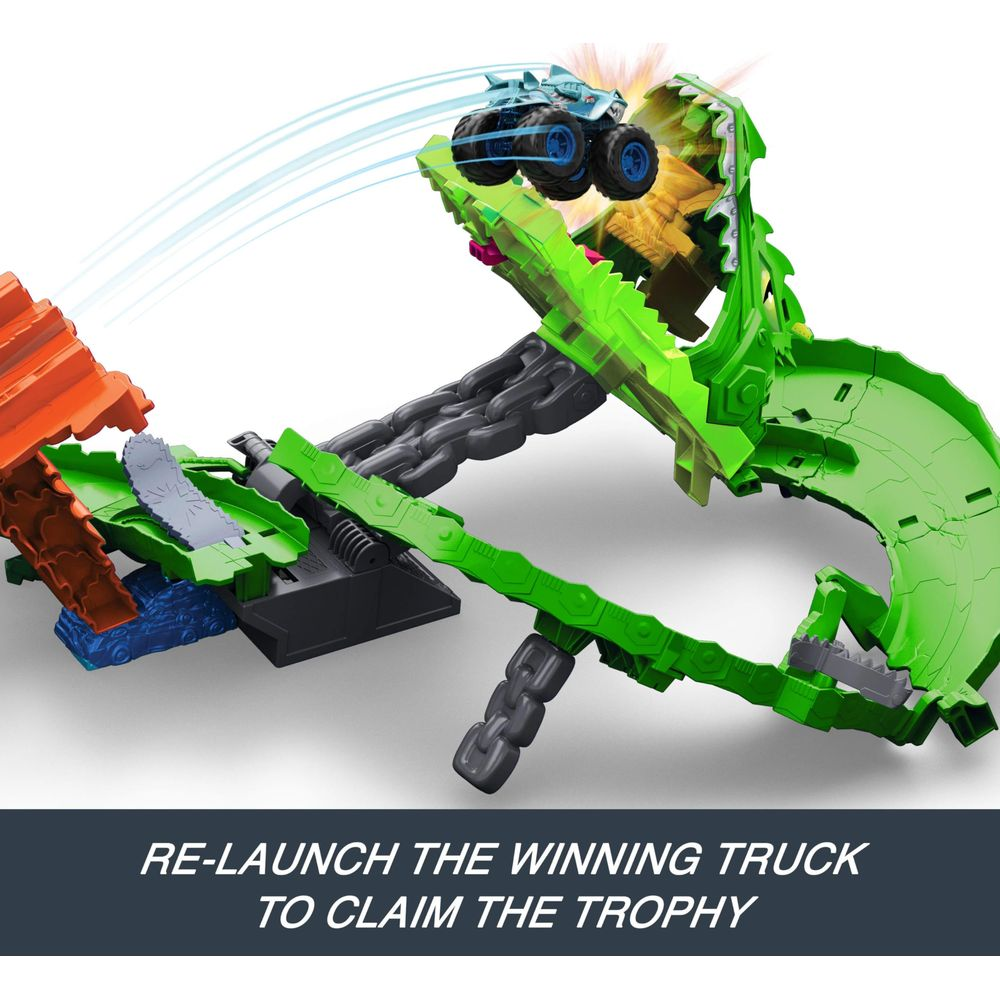 Niebieski zabawkowy monster truck przeskakuje przez zielony tor wyścigowy smoka.