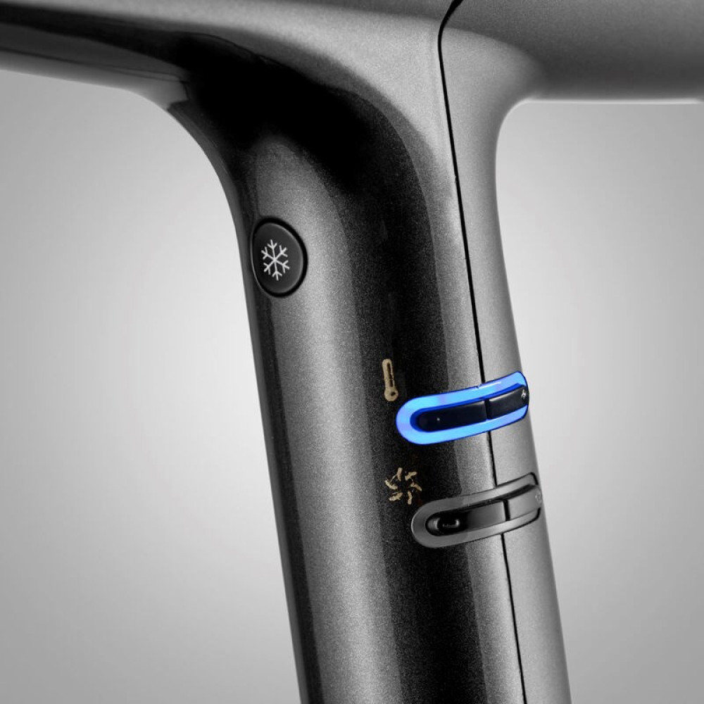 Zbliżenie ciemnej suszarki do włosów z niebieskimi światłami i symbolami.