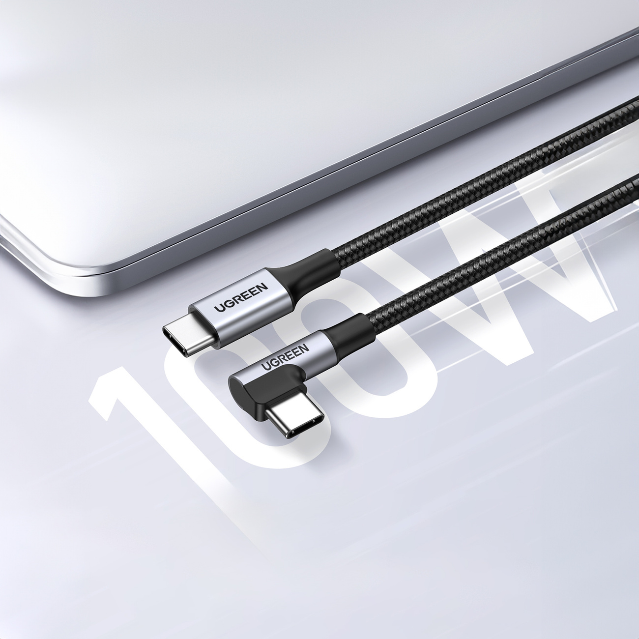 Due cavi USB-C UGREEN con fili neri intrecciati e connettori argentati su un laptop.