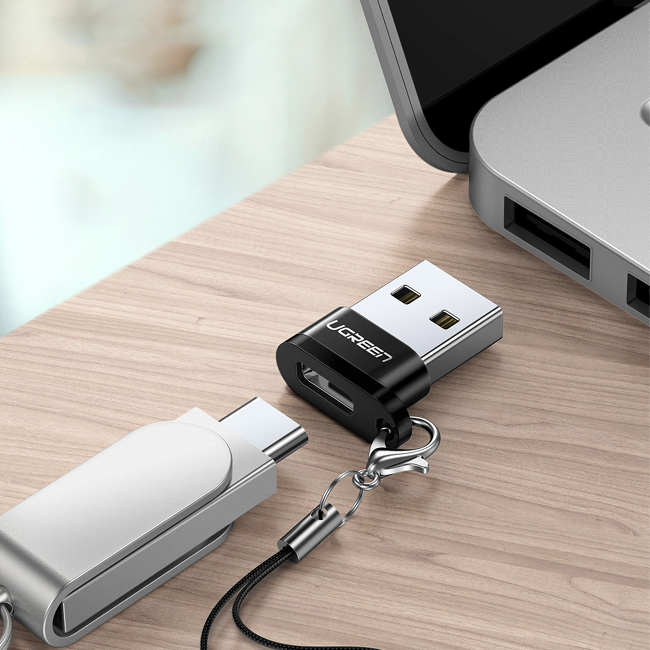 Ahşap bir masada USB-C'den USB-A'ya adaptör ve USB-A adaptörü.