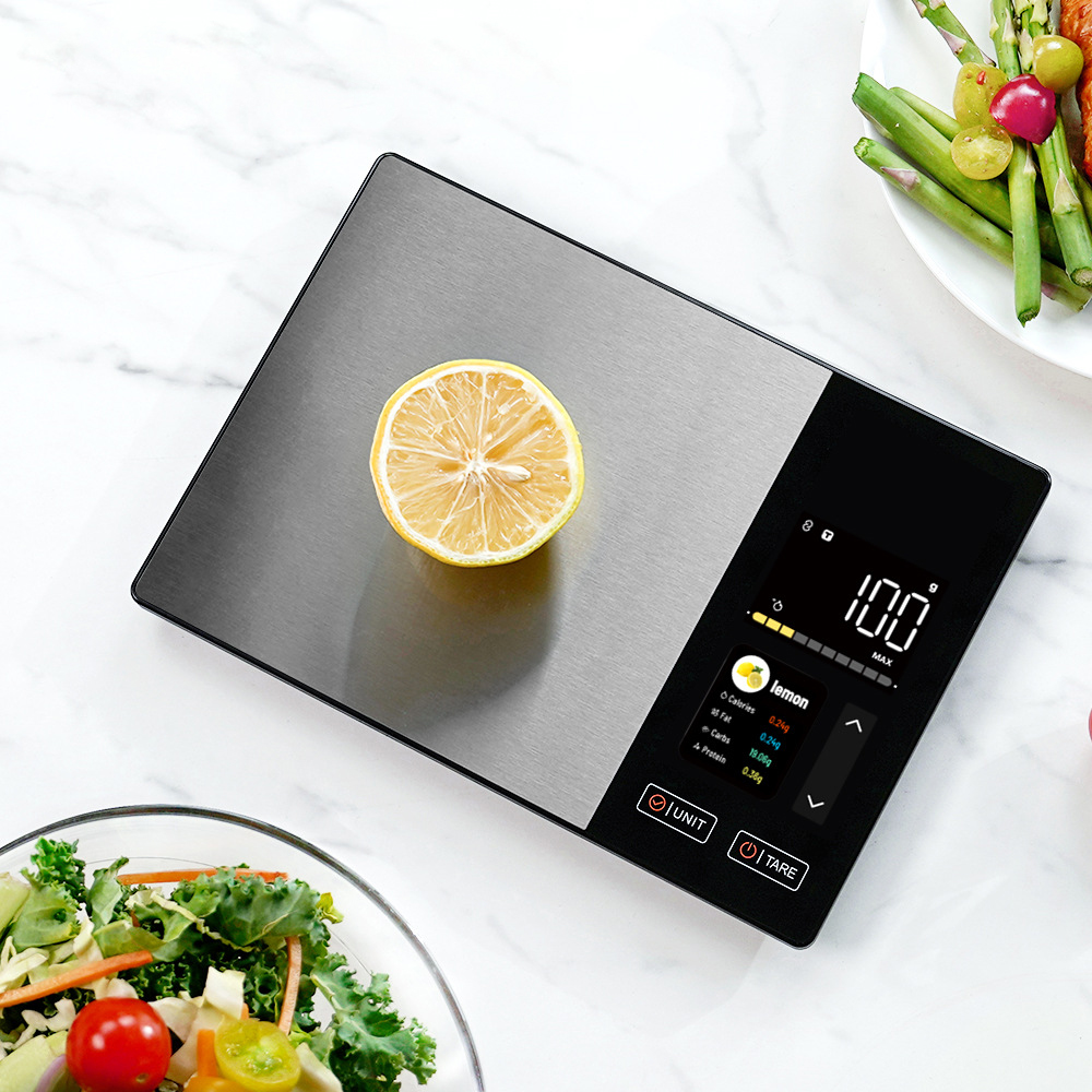 Eine digitale Küchenwaage mit einer Zitronenscheibe und Salatschüssel.