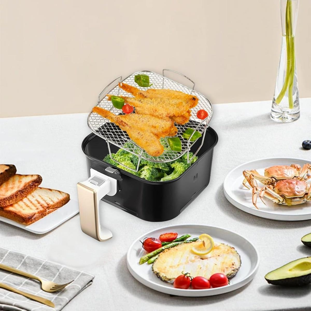 Ein schwarzer Heißluftfritteusenkorb mit Fisch, Brokkoli und Paprika. Daneben Toast, Fisch und Krabben.