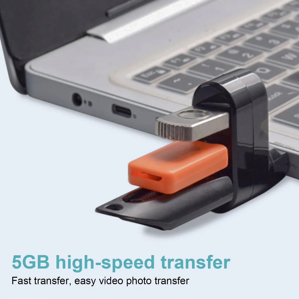 Ein orangefarbener USB-Stick steckt in einem schwarzen Adapter, der an einem Laptop befestigt ist.