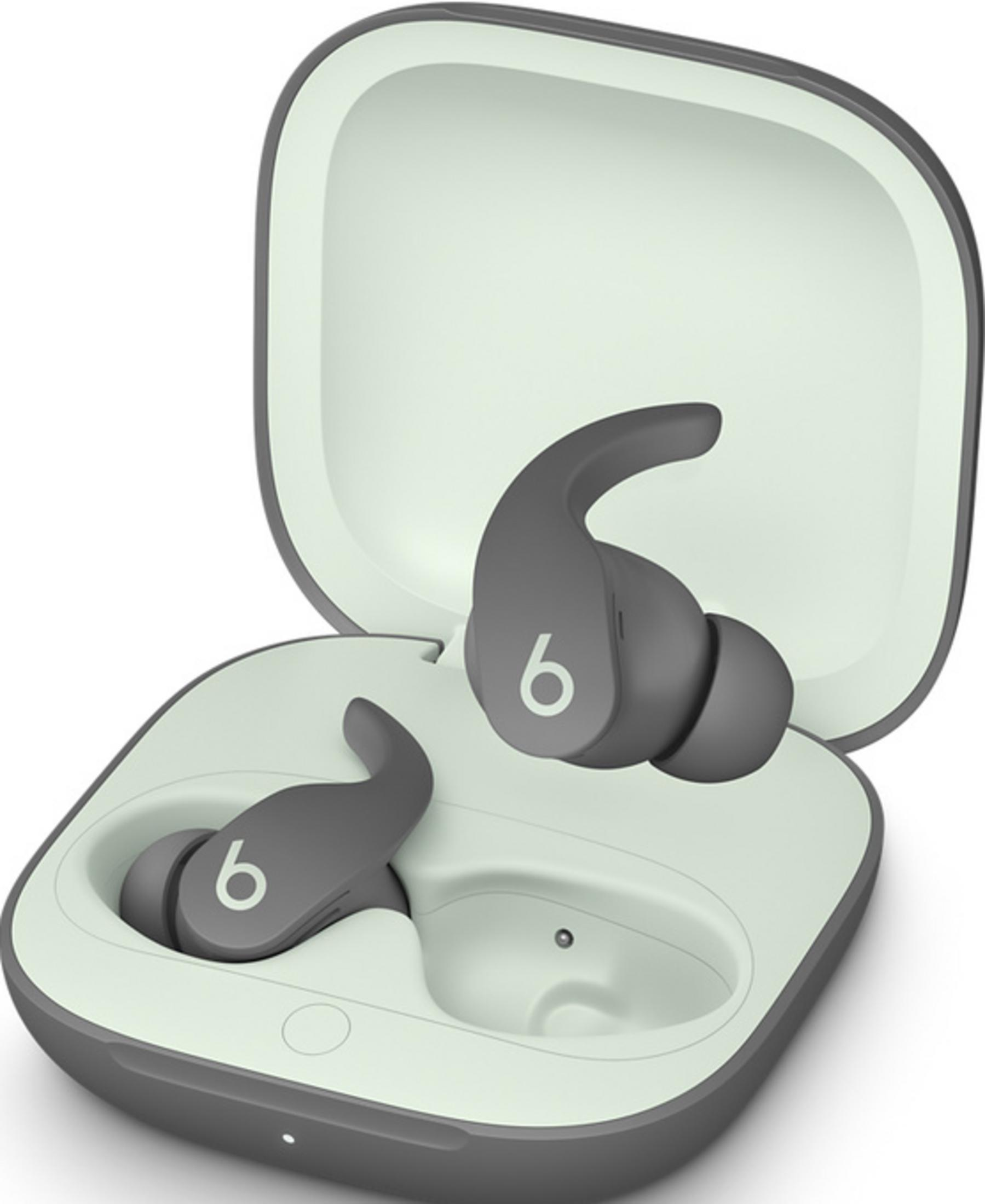Szare słuchawki bezprzewodowe w otwartym etui ładującym. Wnętrze etui jest jasnozielone.