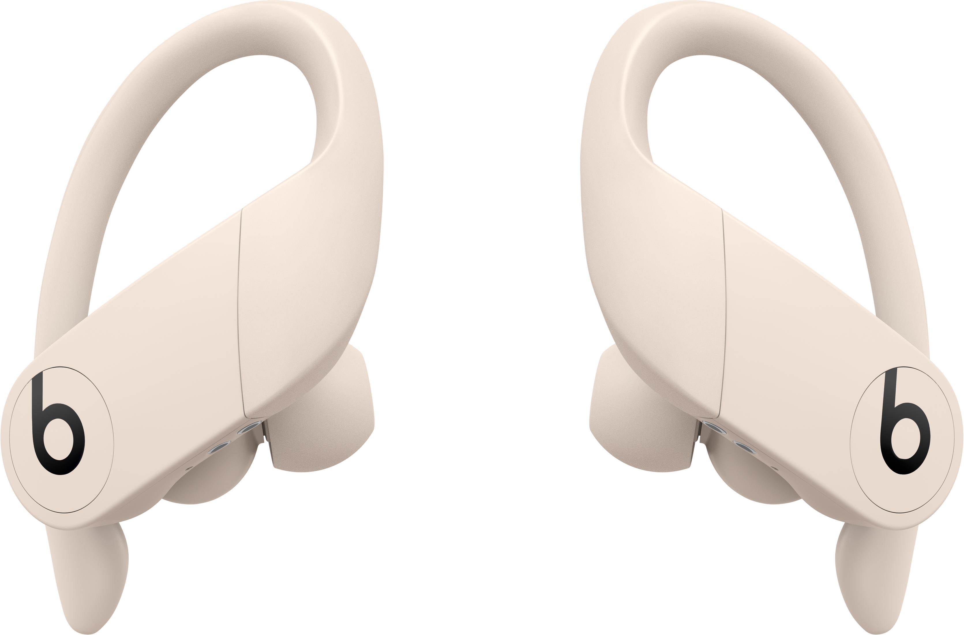 Two cream-colored wireless earbuds with ear hooks and black 'b' logo.