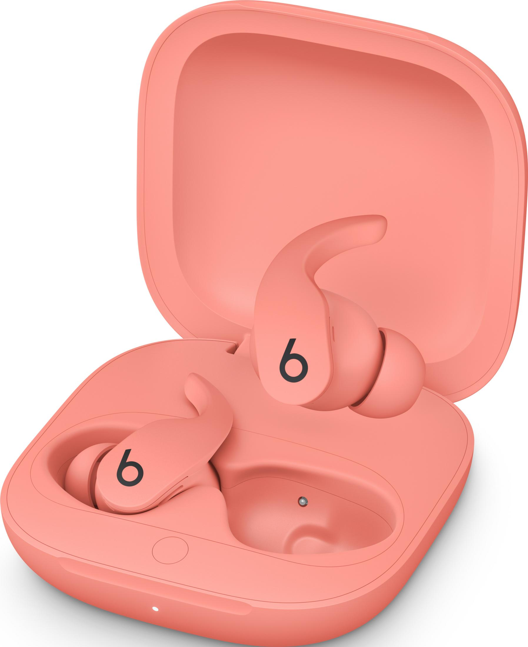 Koralowe etui ładujące z dwoma słuchawkami. Czarne logo 'b' na każdej.