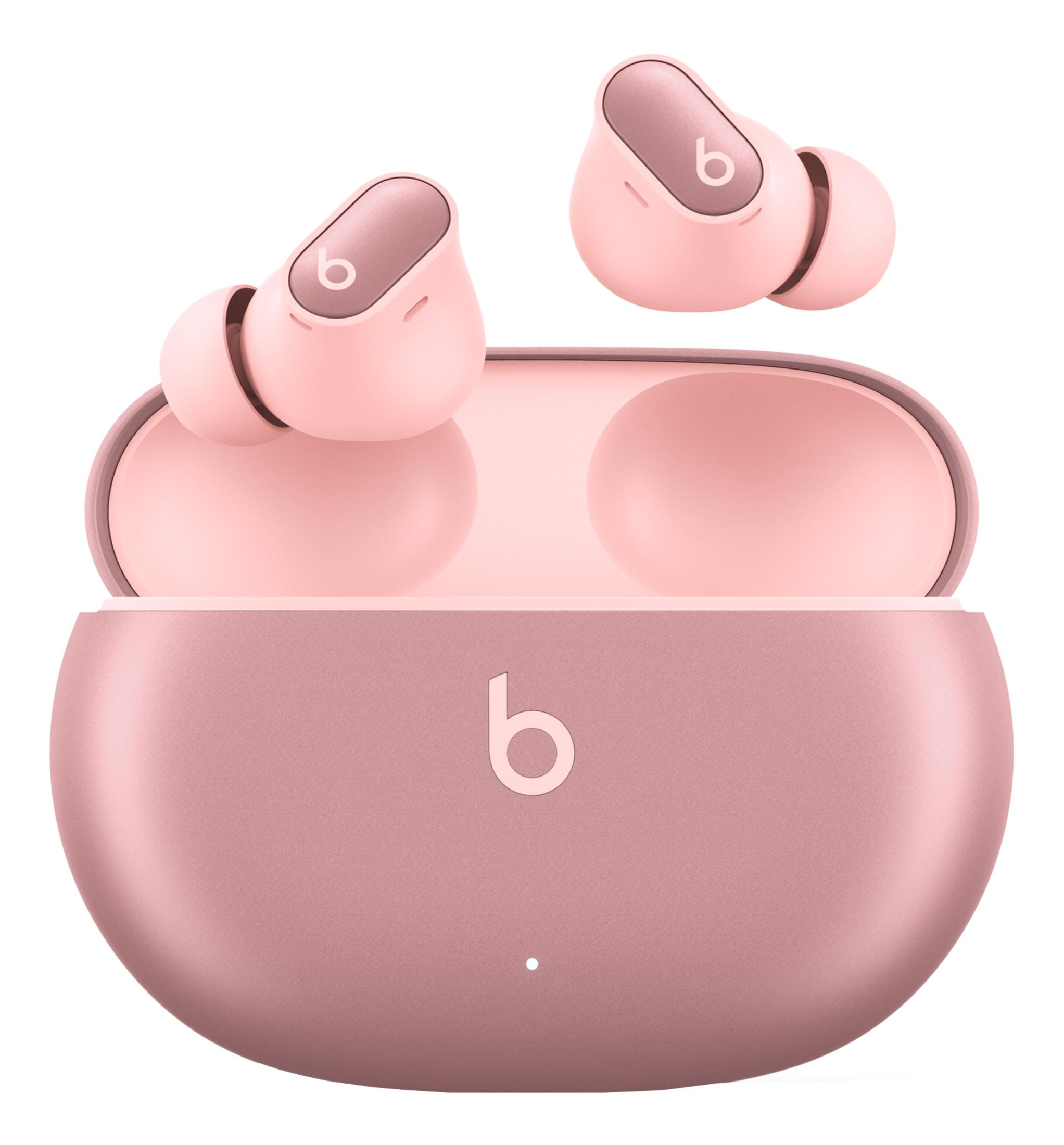 Dwa różowe słuchawki bezprzewodowe w otwartym etui ładującym z logo Beats.