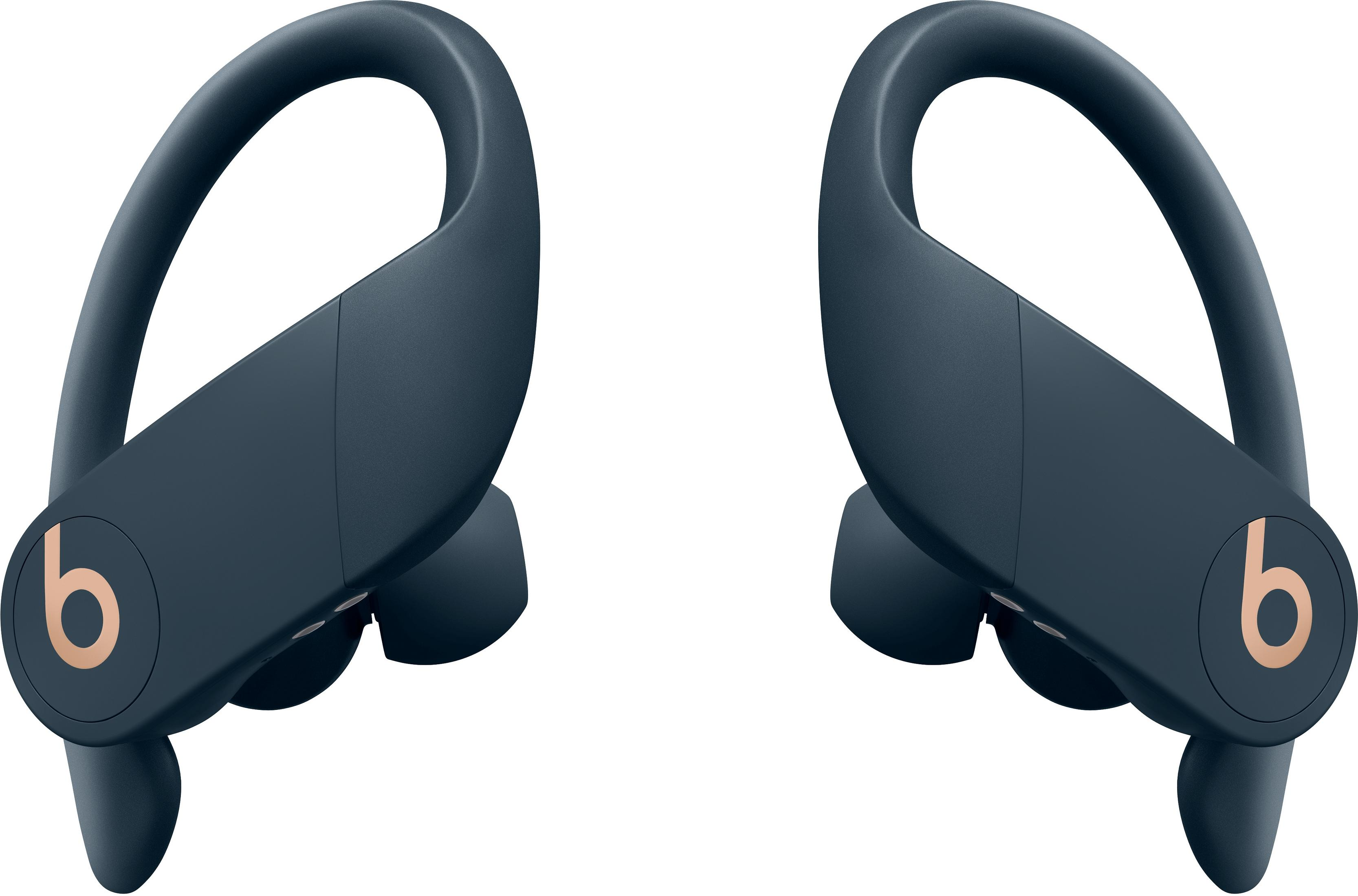 Two dark blue wireless earbuds with gold Beats logo.