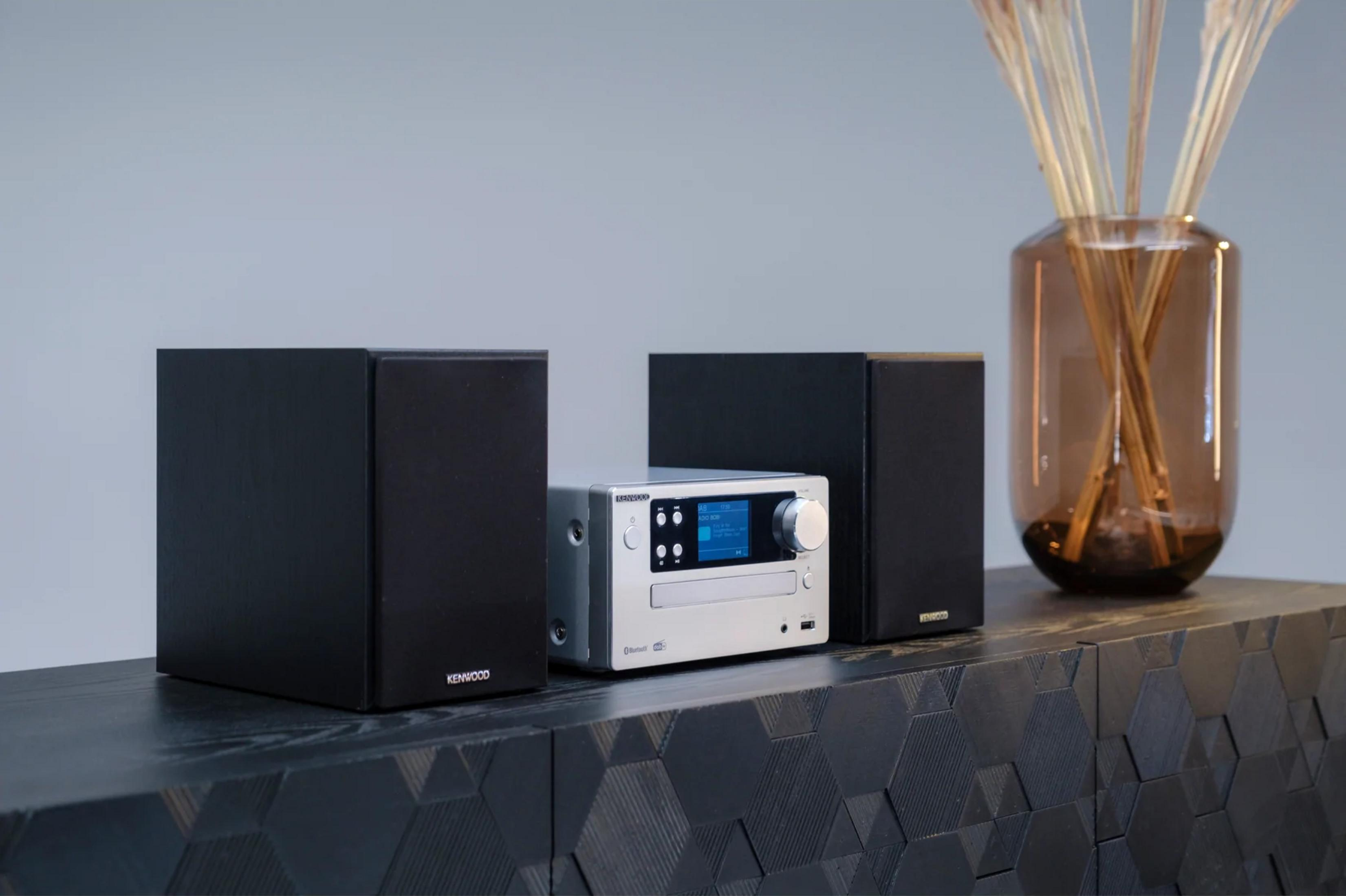 Un sistema stereo Kenwood con due altoparlanti neri e un'unità principale argentata.