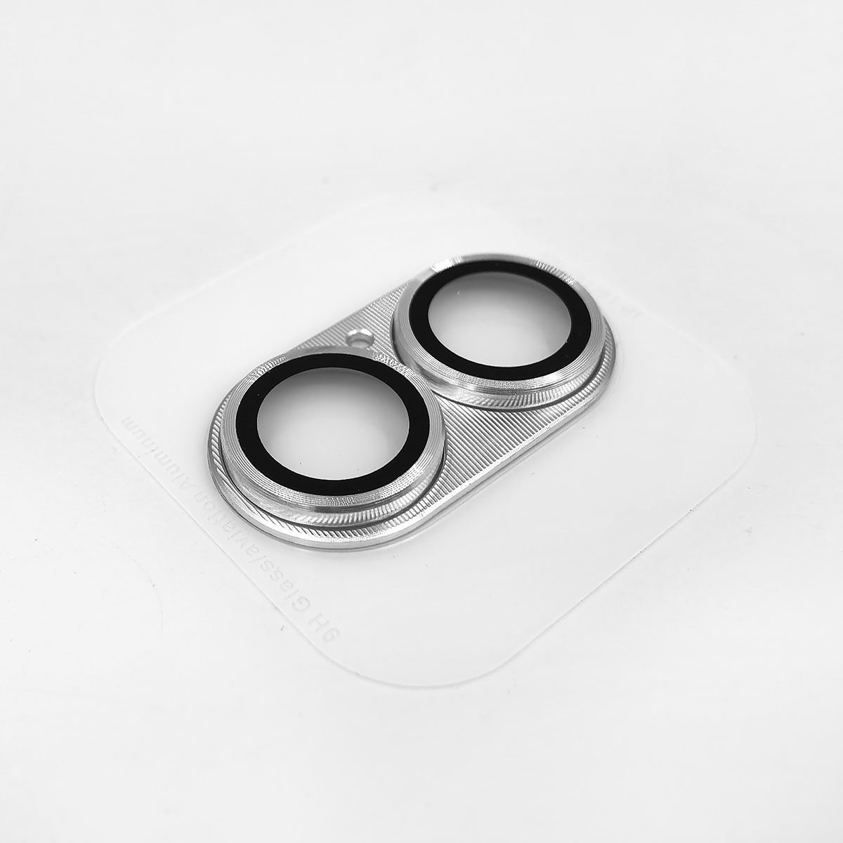 Anello in metallo argentato con due aperture circolari su sfondo bianco.
