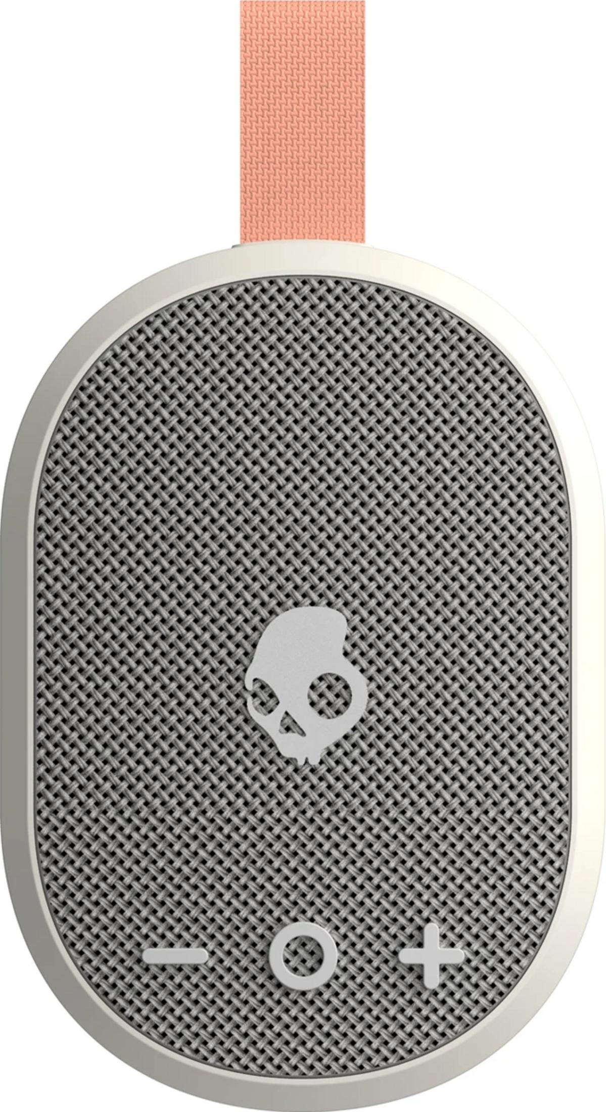 Ein ovaler, cremefarbener Lautsprecher mit Stoffgitter und einem Totenkopf-Logo.