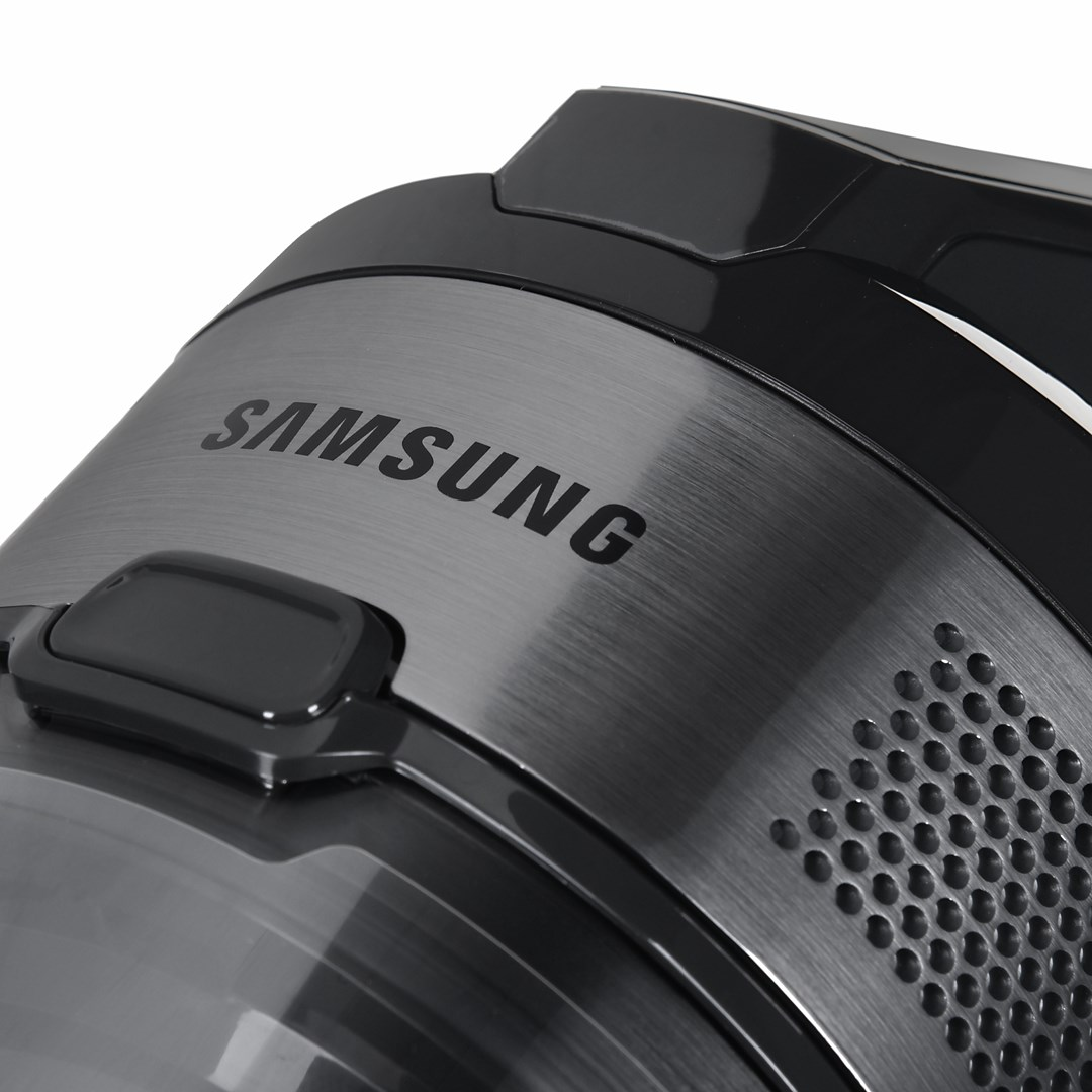 Primer plano de una aspiradora Samsung negra con acabado de metal cepillado.