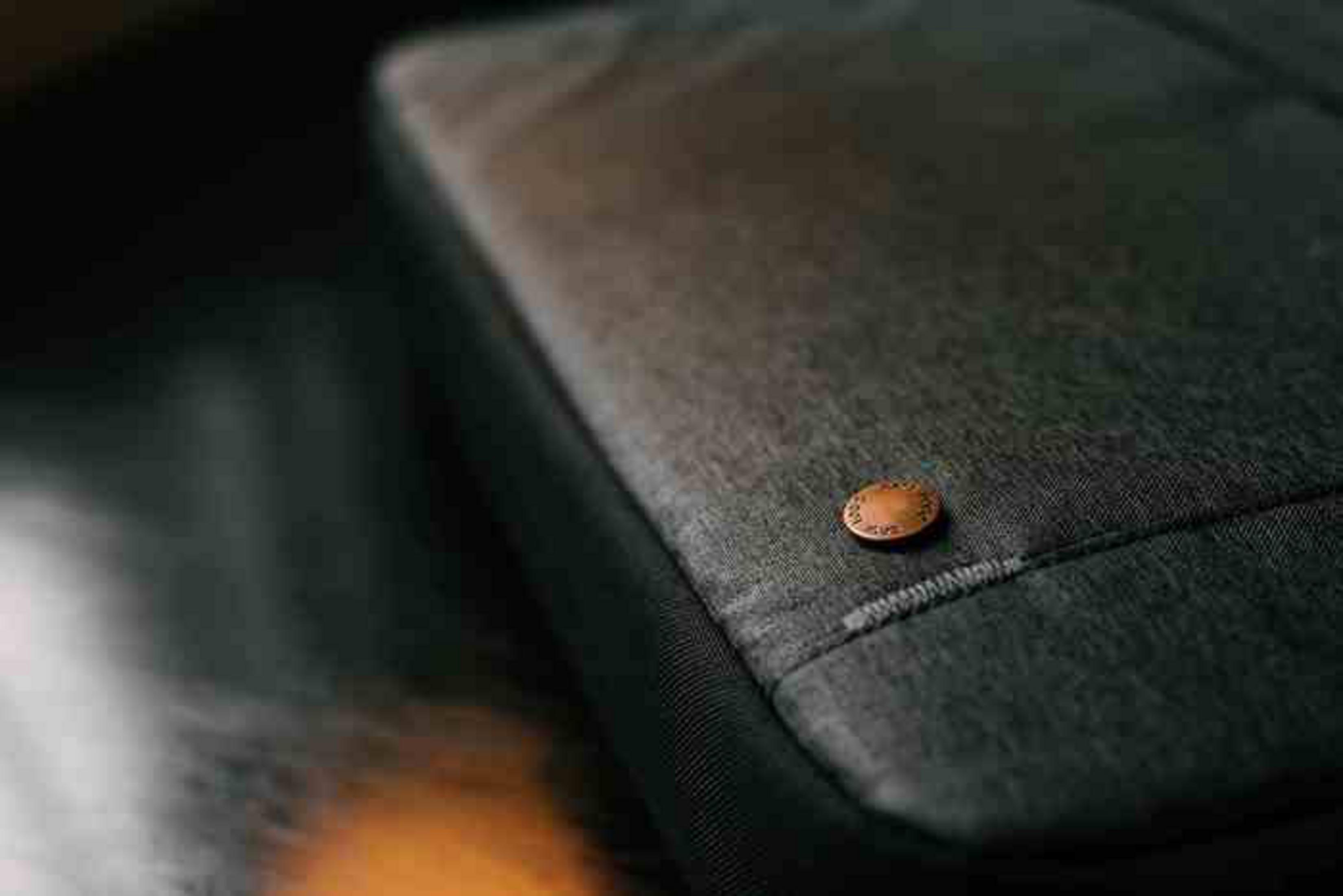 Ciemnoszara torba materiałowa z małym miedzianym guzikiem.