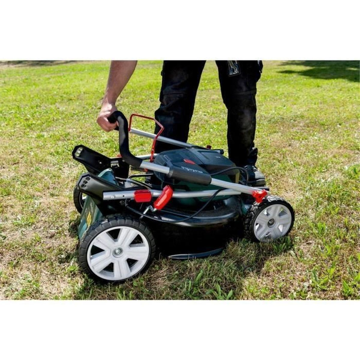 Mann mit Rasenmäher auf Gras
