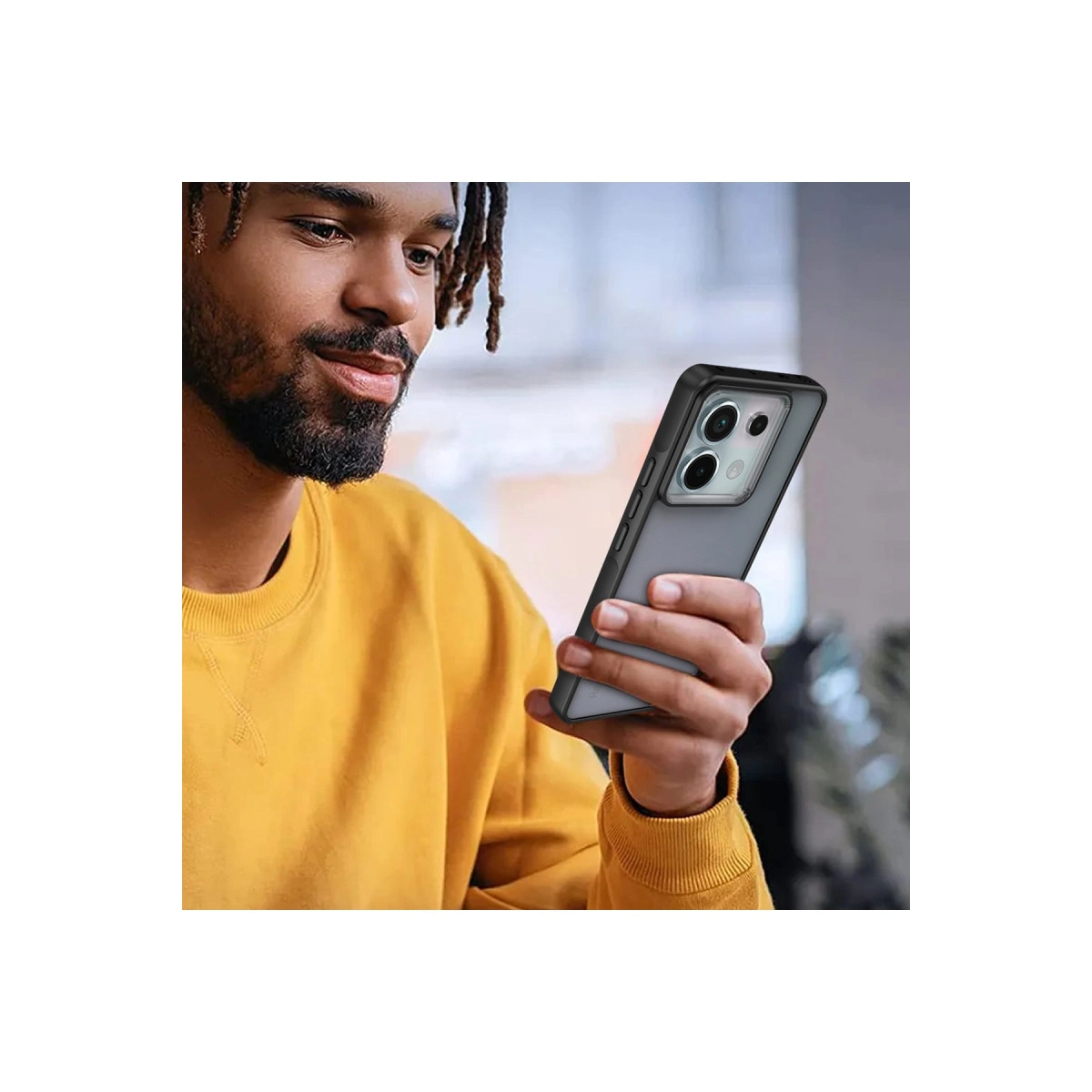Sarı kazaklı bir adam, üç kameralı bir akıllı telefon tutuyor.