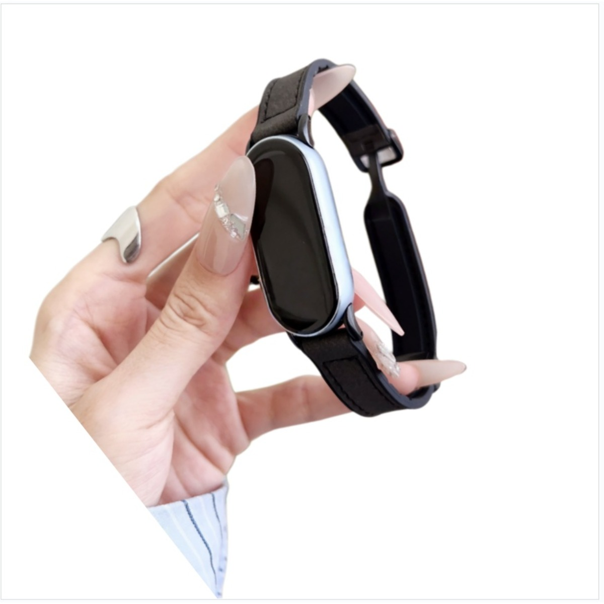 Eine Hand hält eine Smartwatch mit schwarzem Armband und hellem Gehäuse.