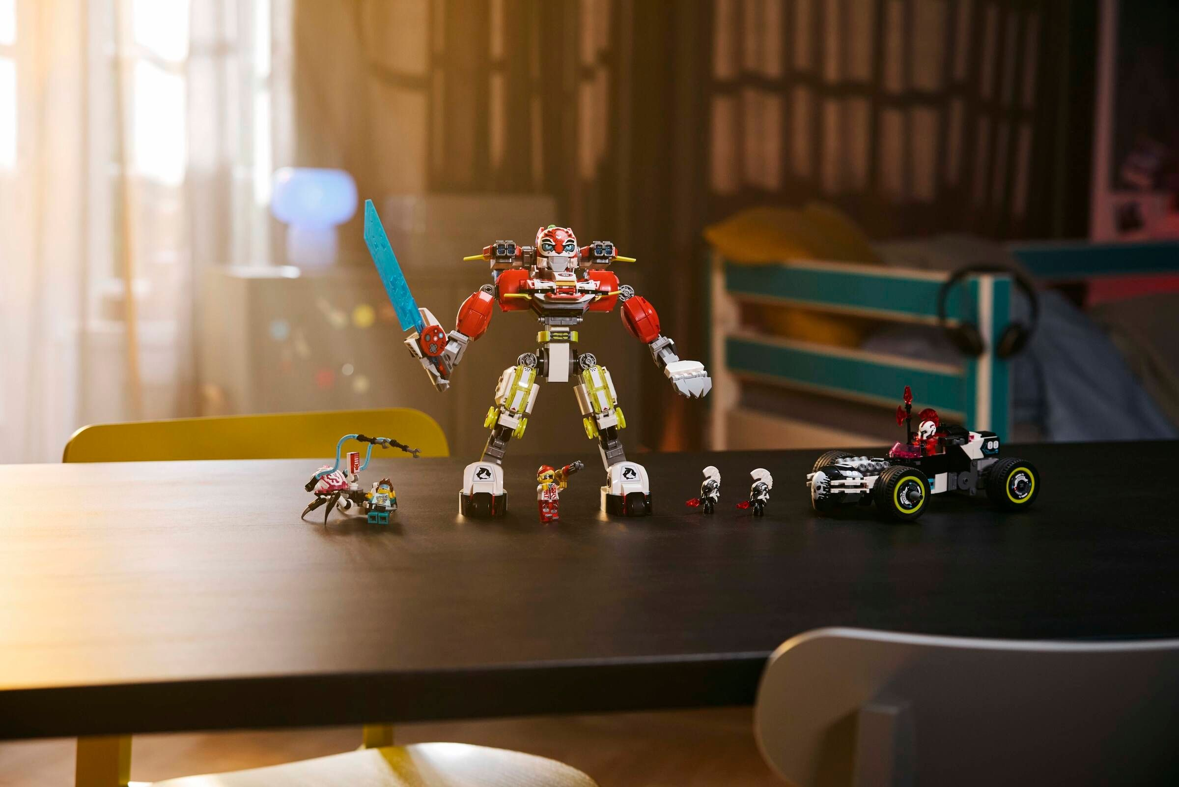 Ein großer roter Roboter mit einem blauen Schwert steht neben Spielzeugfiguren.