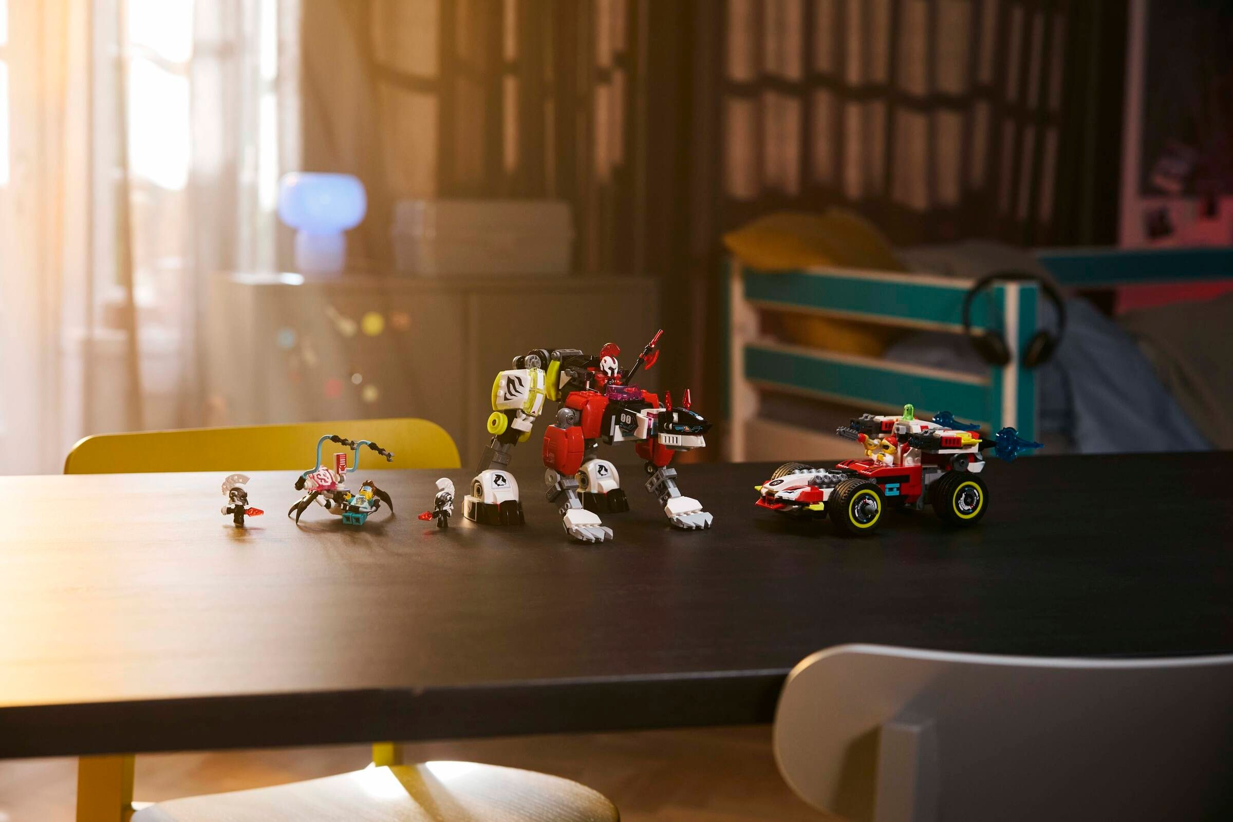 Lego-Spielzeug: Roboter, Fahrzeug und Figuren auf einem Tisch.