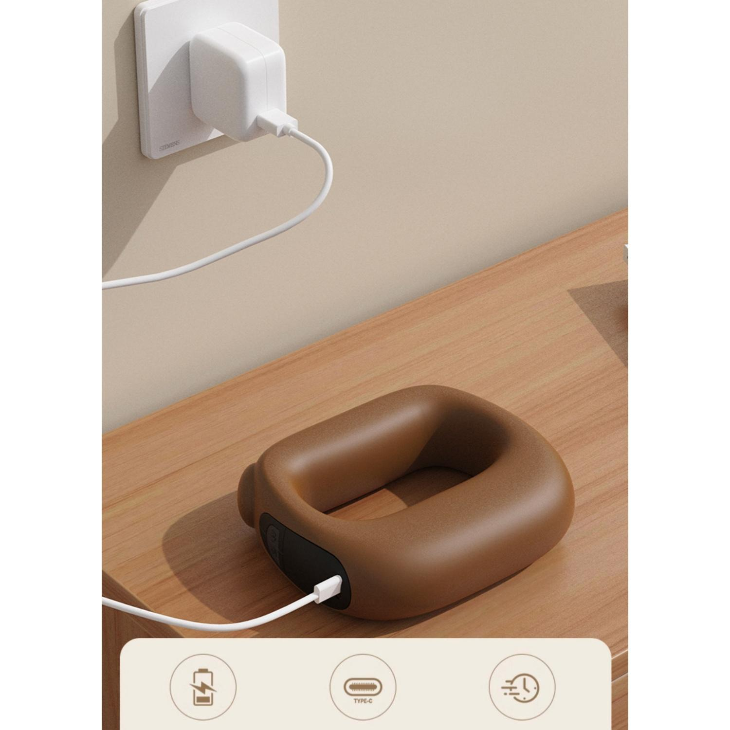 Ein braunes Nackenmassagegerät lädt per USB-C. Ein weißer Stecker steckt in der Wand.