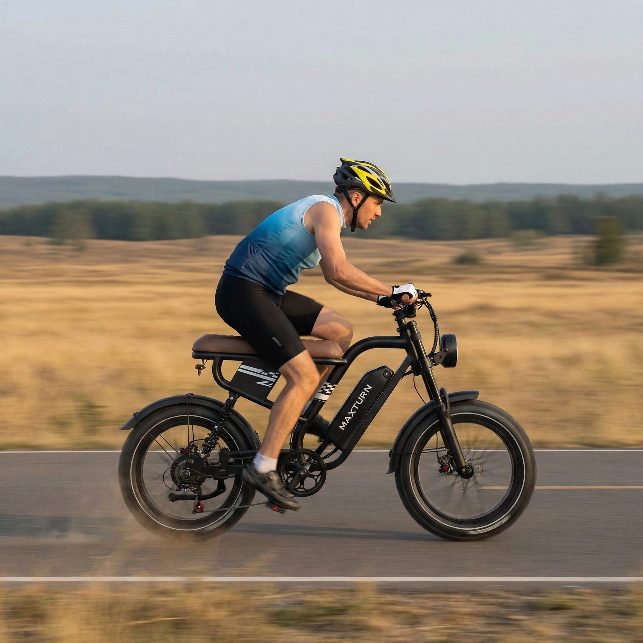 Ein Mann fährt ein schwarzes E-Bike auf einer Straße durch eine Landschaft.