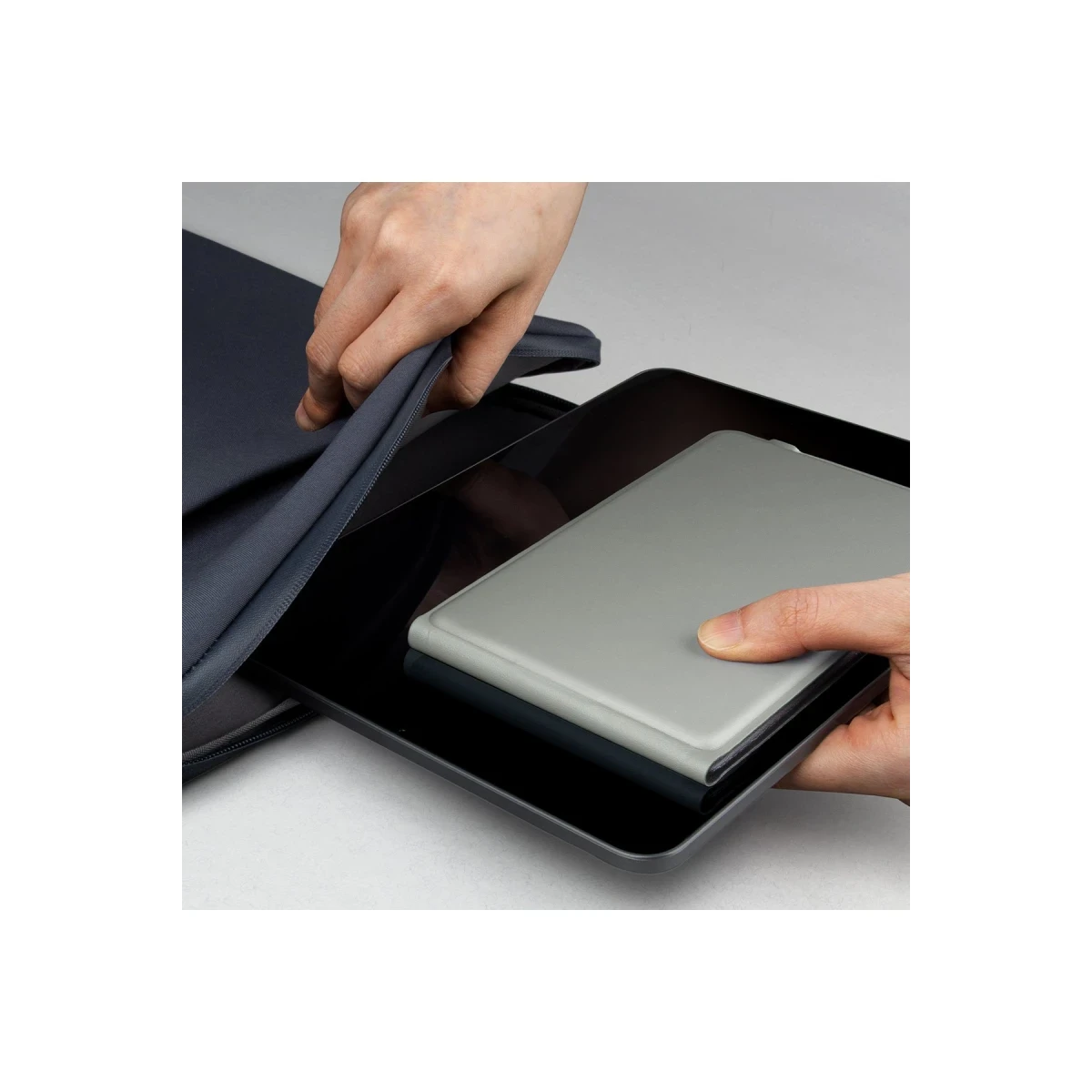 Una custodia grigia per tablet viene fatta scorrere in una custodia più scura.