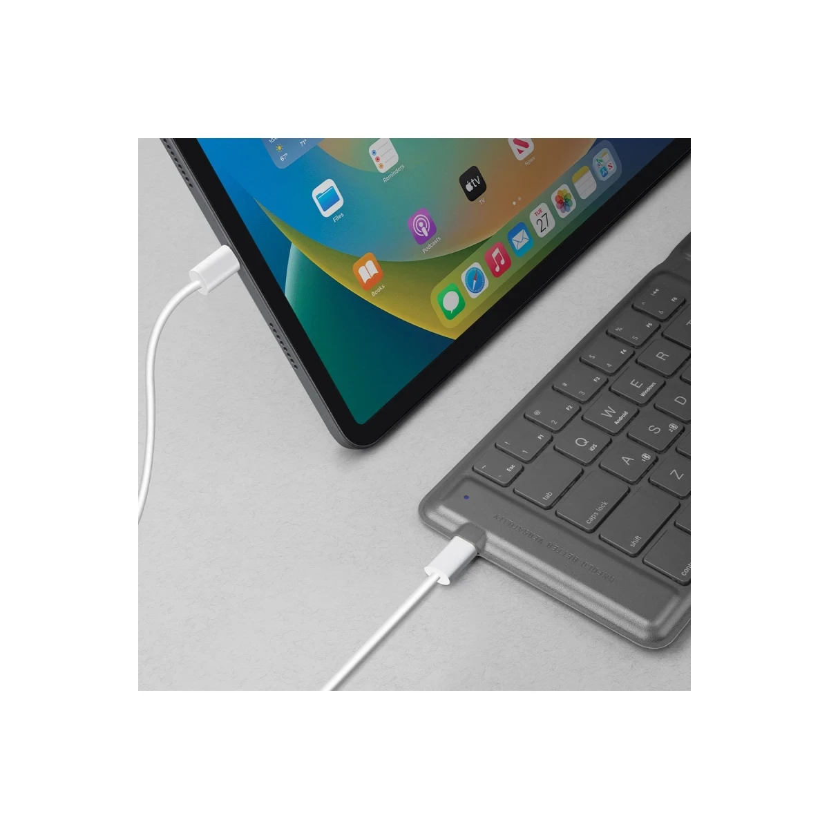 Un tablet con app e una tastiera grigia si collegano tramite cavi USB-C.