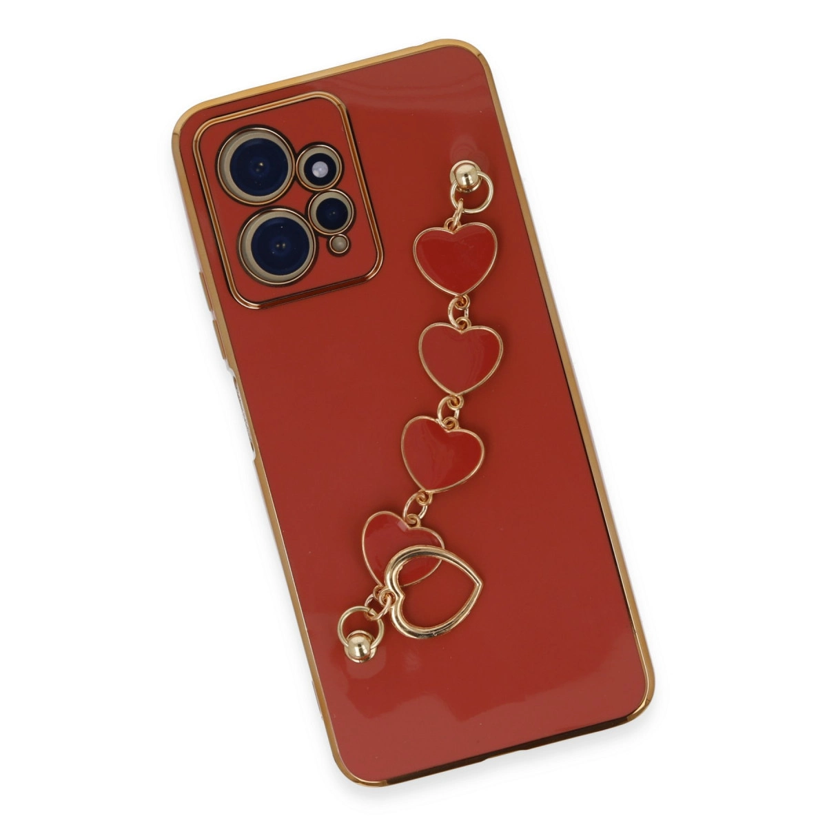 Altın kenarlı kırmızı telefon kılıfı ve kalp şeklinde takılar. Yakın çekim.