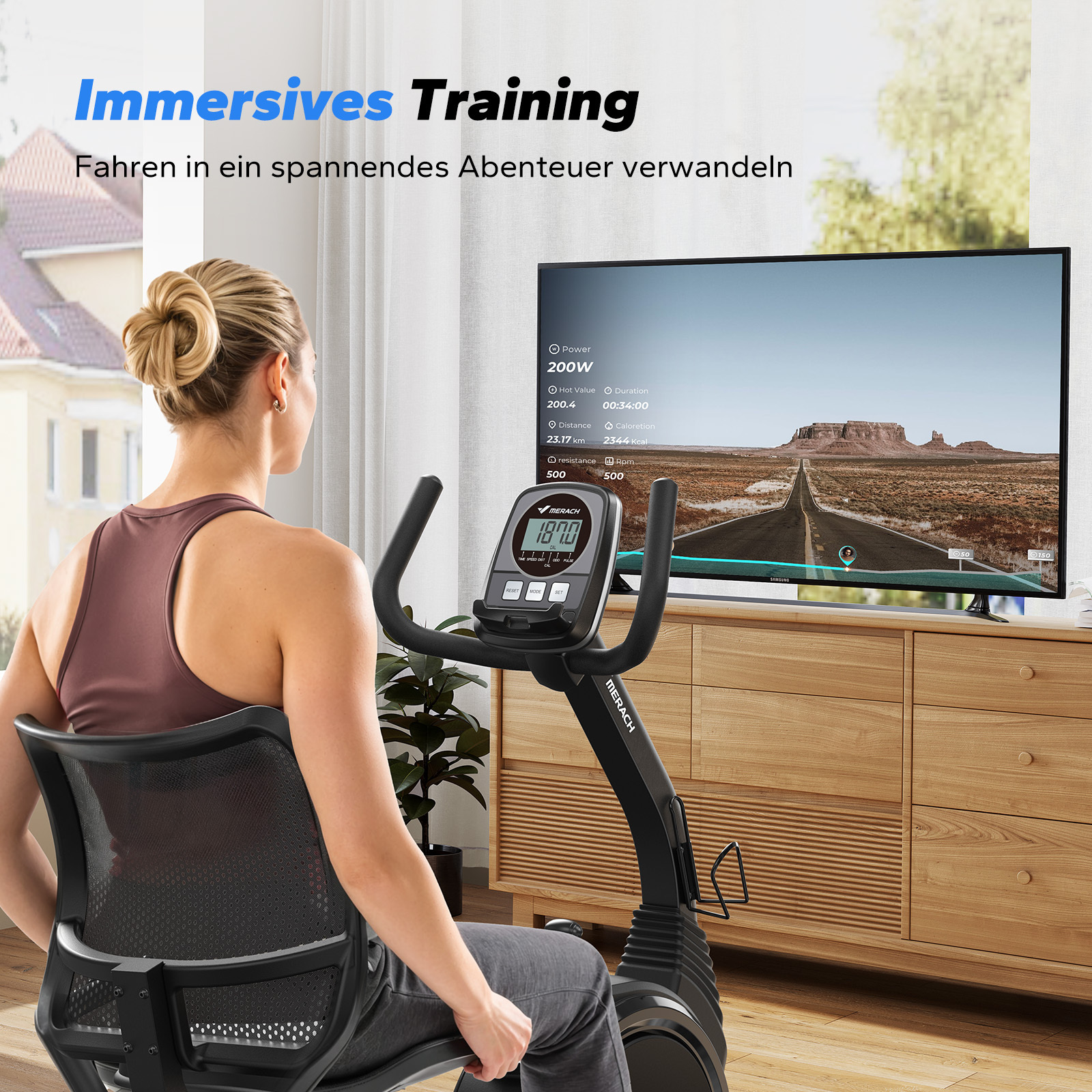 Eine Frau trainiert auf einem Heimtrainer vor einem großen Bildschirm mit einer Wüstenlandschaft.