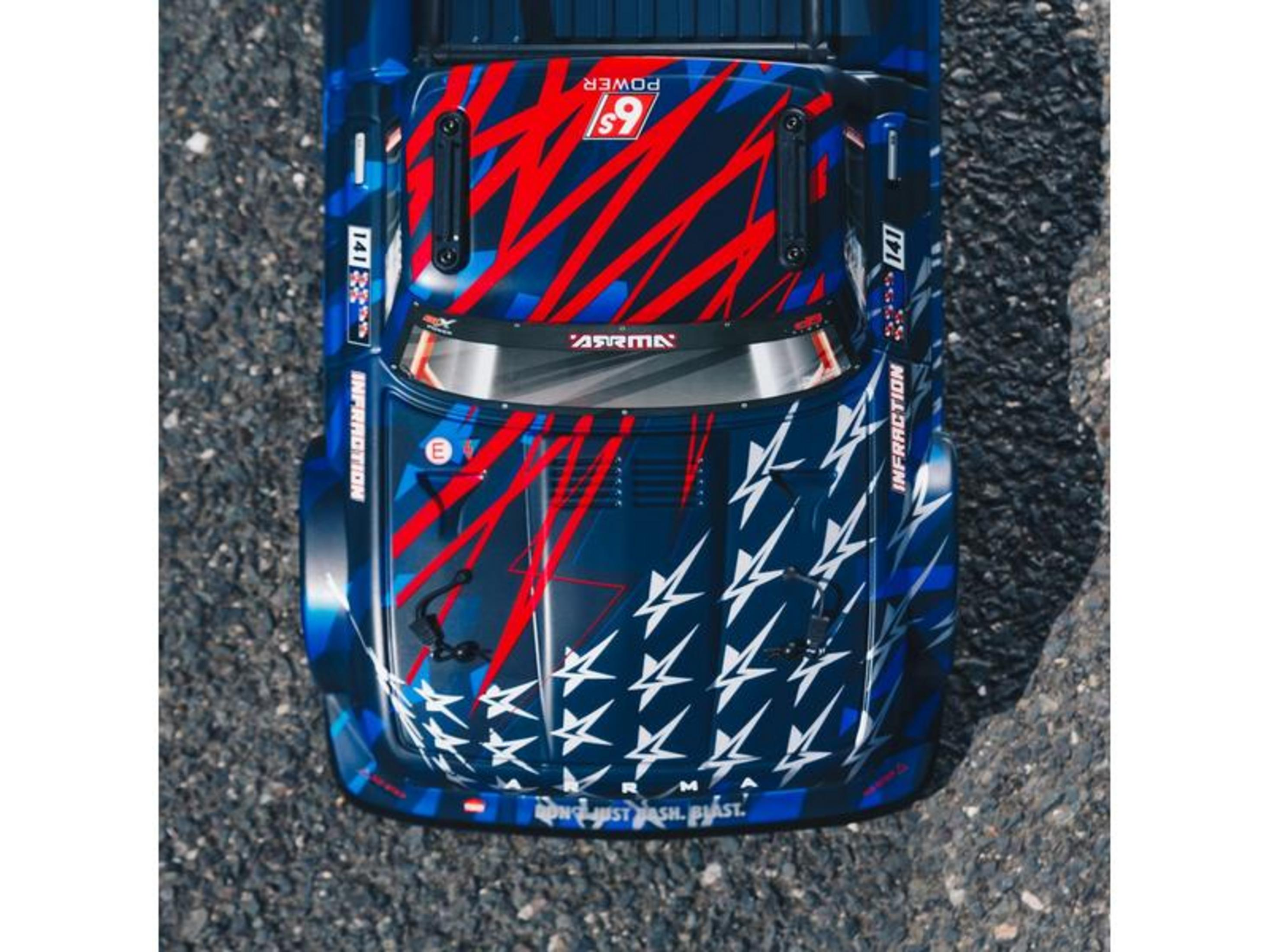 Une voiture RC bleue avec des graphismes d'étoiles rouges et blancs sur asphalte.