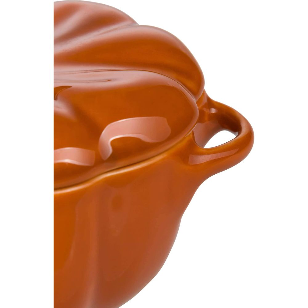 Pomarańczowy ceramiczny garnek w kształcie dyni z uchwytami, na białym tle.