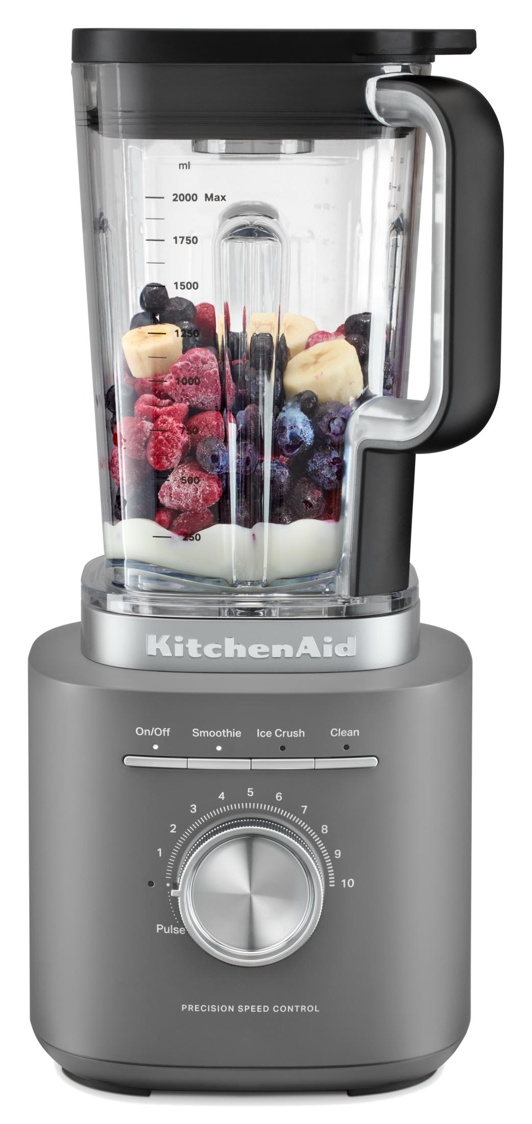Grauer KitchenAid Mixer mit Beeren, Bananen und Joghurt im Behälter.